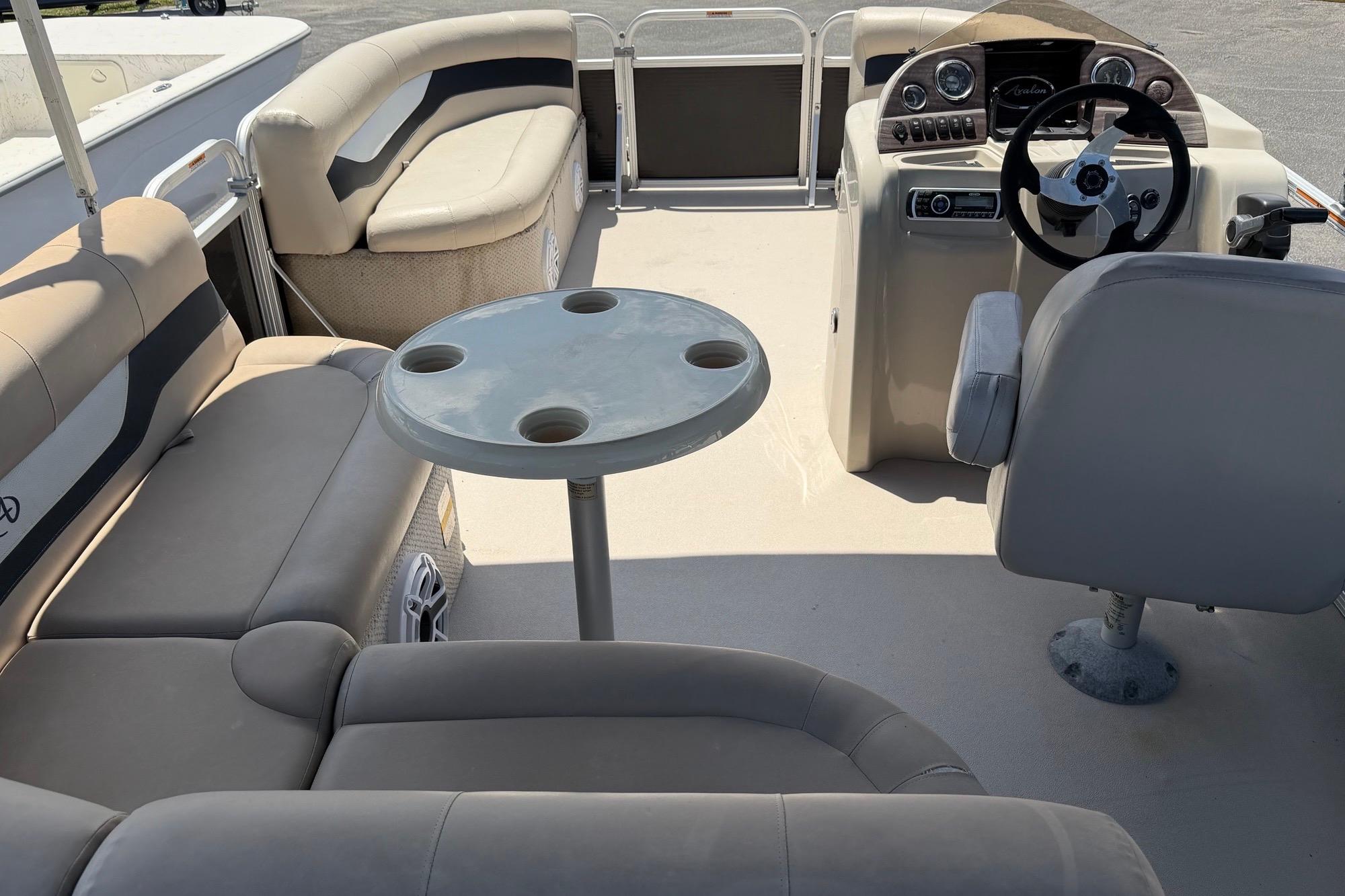 2014 Avalon 1900 pontoon boat interior with beige seating and steering console.