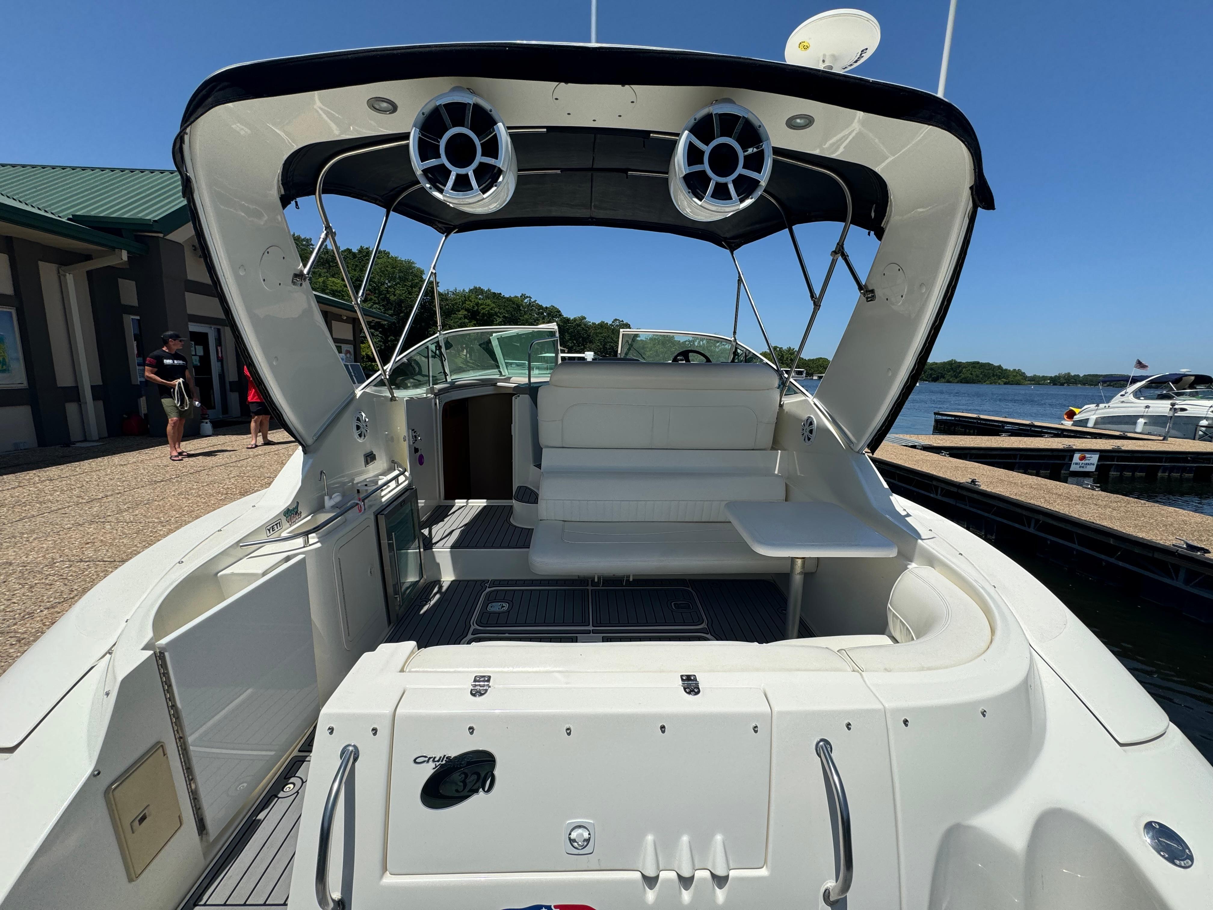 2004 Cruisers Yachts 320 Express boat interior with seating and speakers, docked by the water.