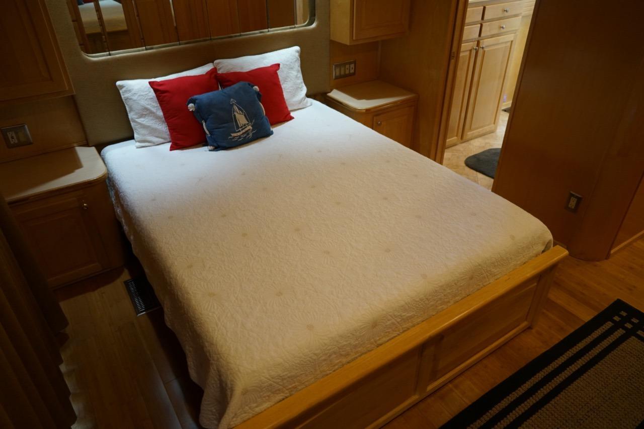 Cozy bedroom in 2000 Stardust Cruisers houseboat with nautical-themed pillows.