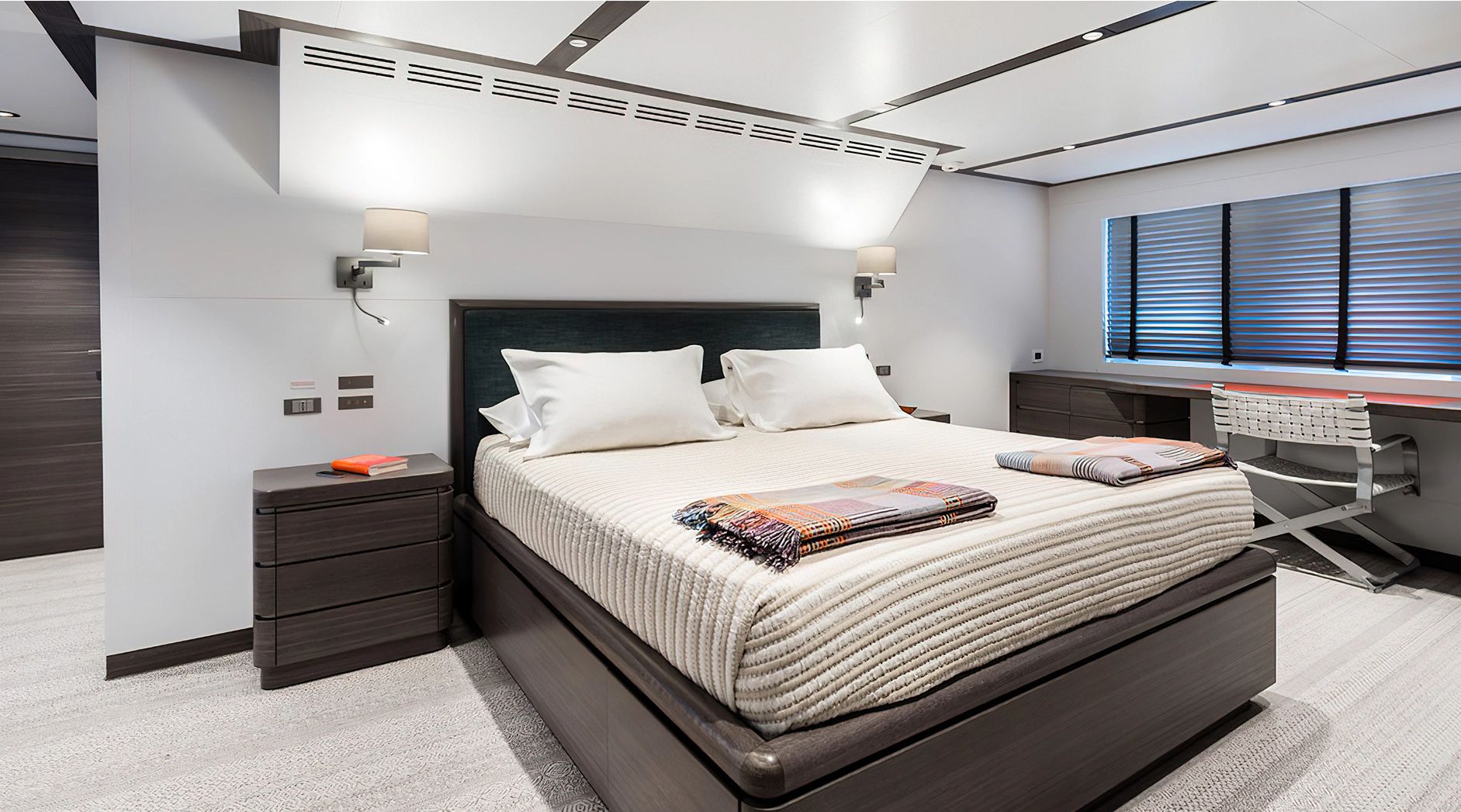 Luxurious bedroom with modern design, double bed, desk, and stylish lighting.