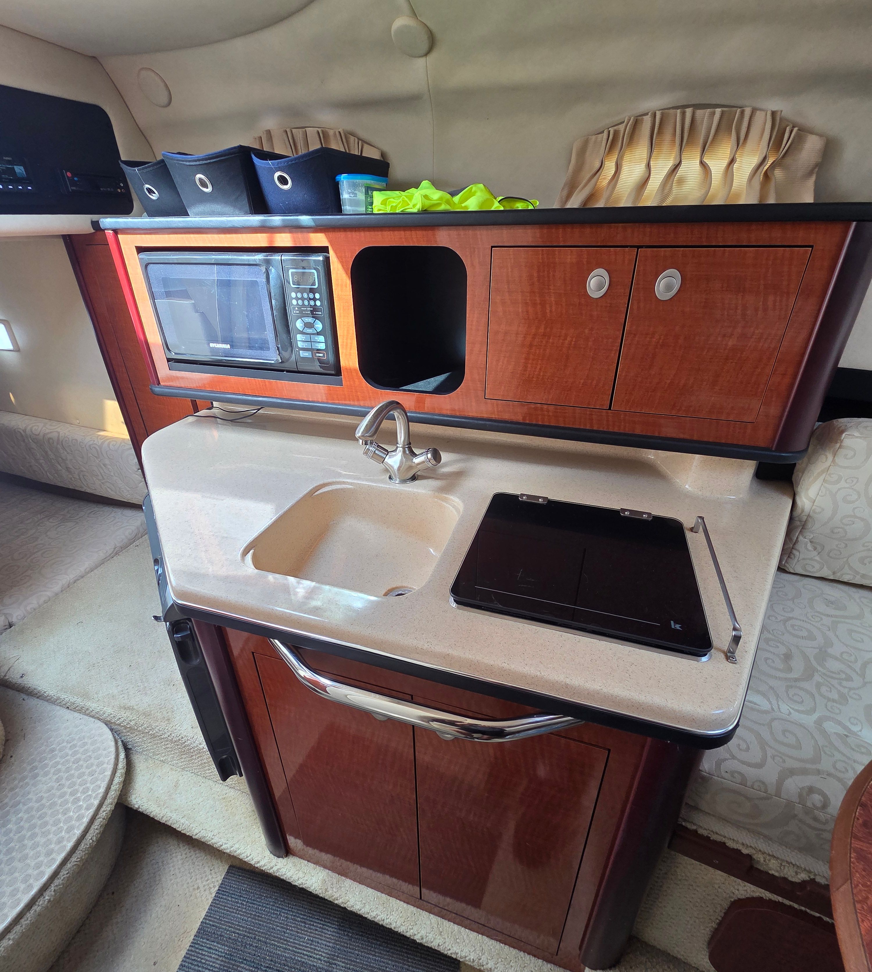 Galley area of a 2005 Sea Ray Sundancer 260 with sink, microwave, and storage.