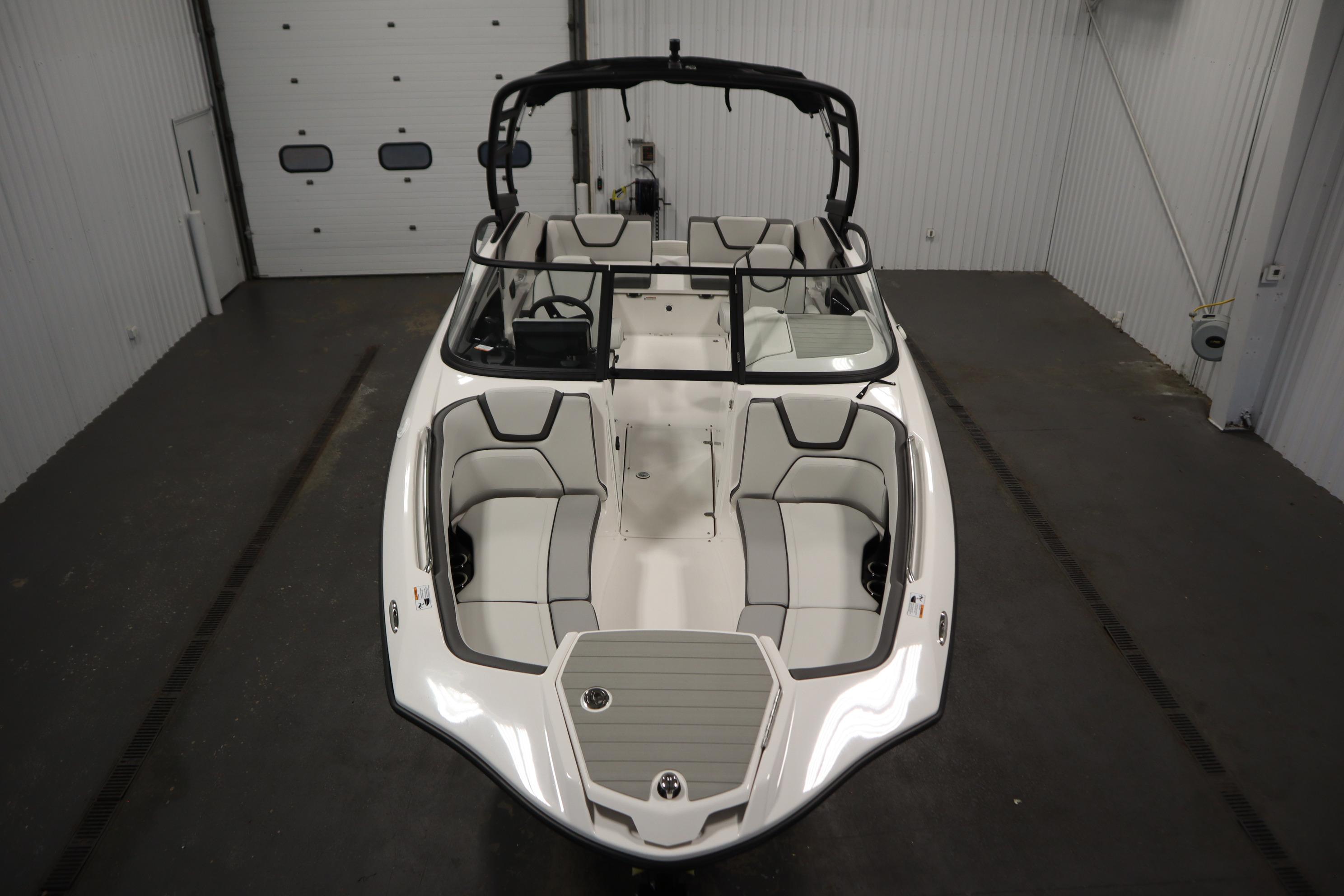 2026 Yamaha Boats AR250 in a garage, showcasing sleek design and spacious seating.