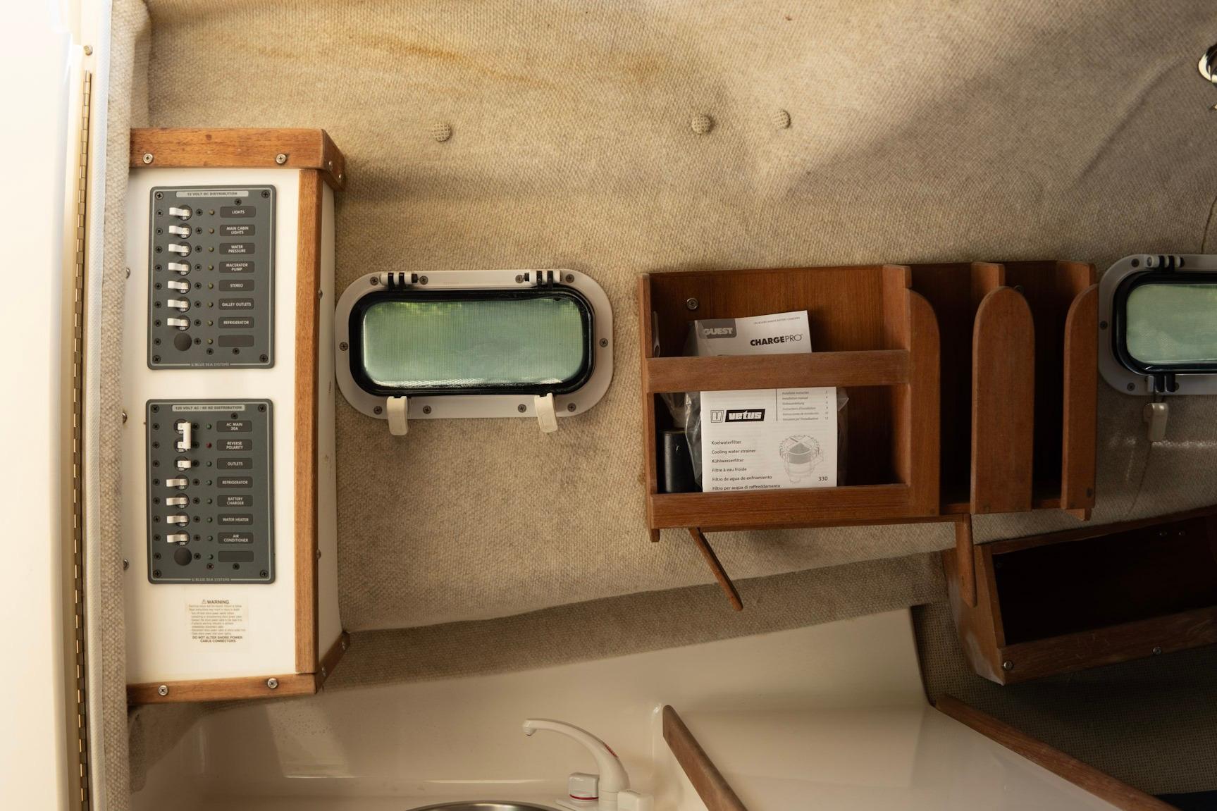 Interior of 2006 Atlas Boat Works Acadia 25, featuring control panels and wooden storage compartments.