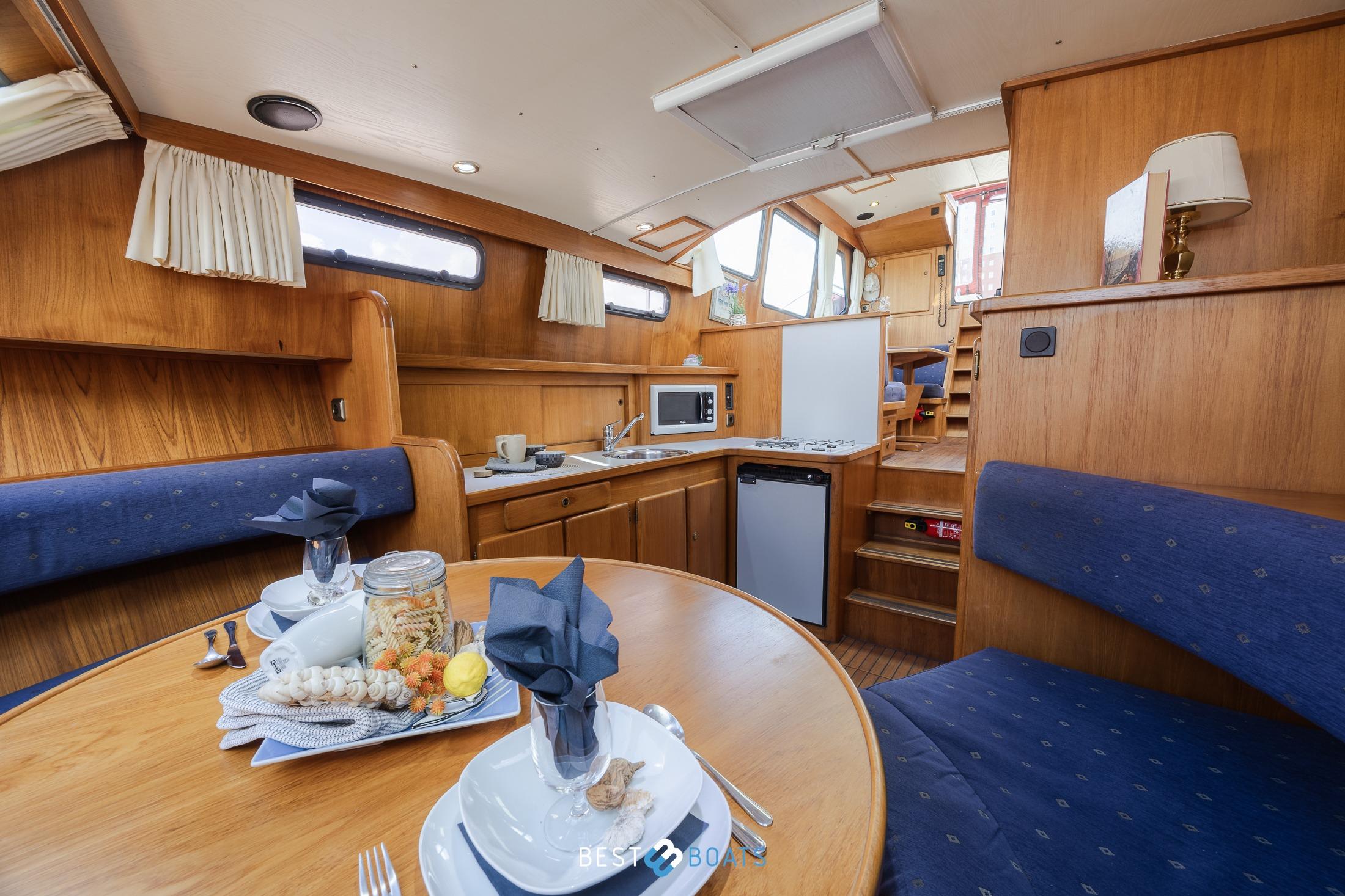 Cozy interior of 1992 Linssen 37 SE yacht with dining area and kitchenette.