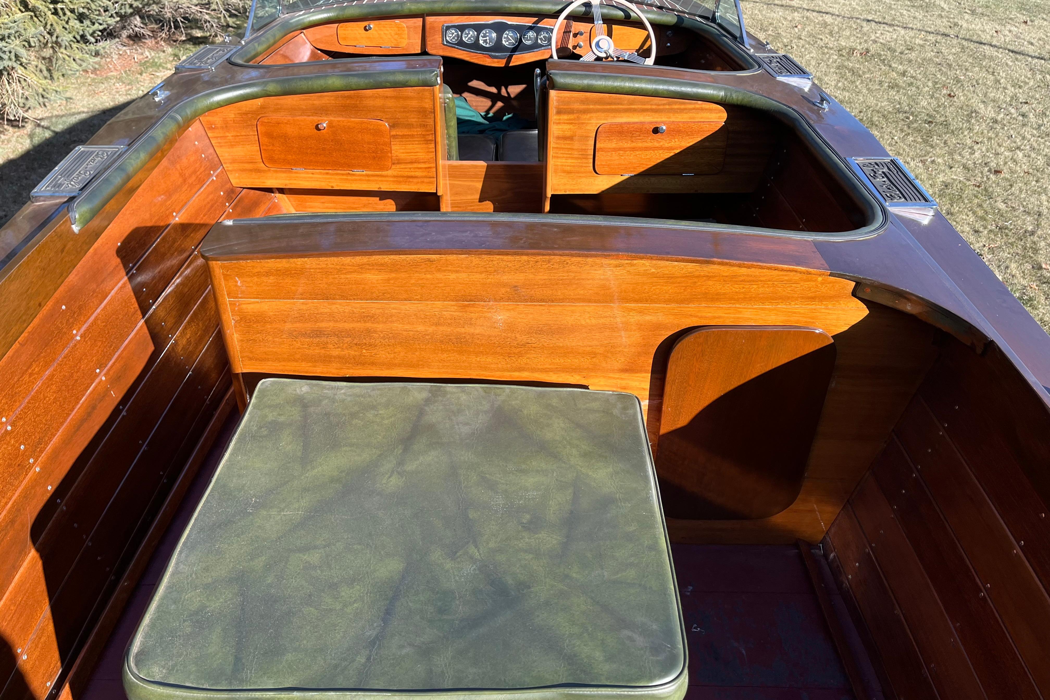 1938 Chris-Craft 28 Sportsman boat interior with polished wood and green upholstery.