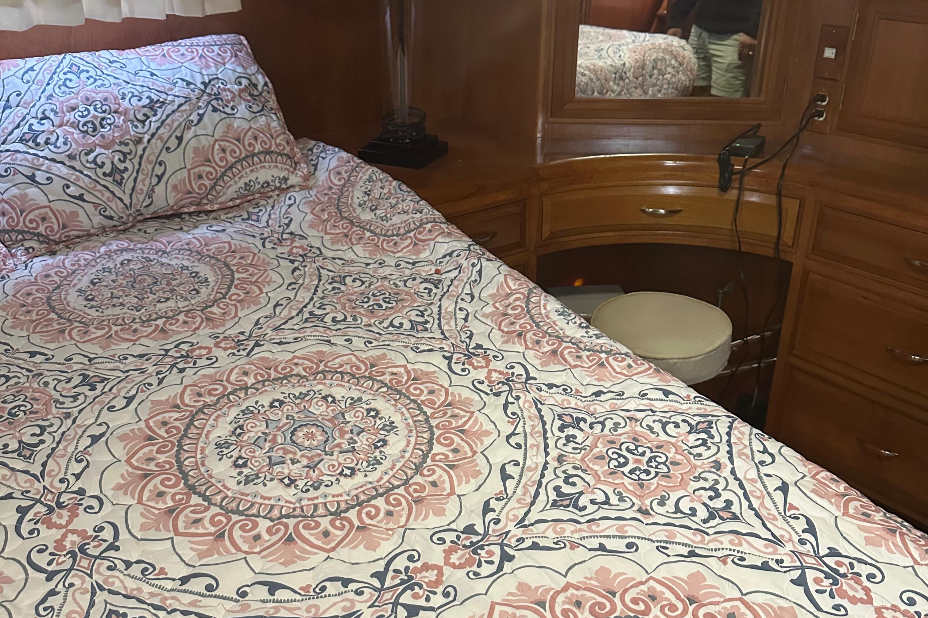 Cozy bedroom in 1988 Ocean Alexander 42 aft cabin yacht with patterned bedding.