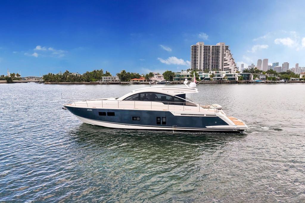 Luxury 2012 Fairline Targa 58 yacht cruising near urban skyline on a sunny day.
