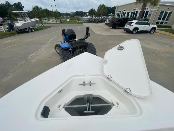 2024 Key West 203 FS boat with open storage compartment, parked on a trailer.