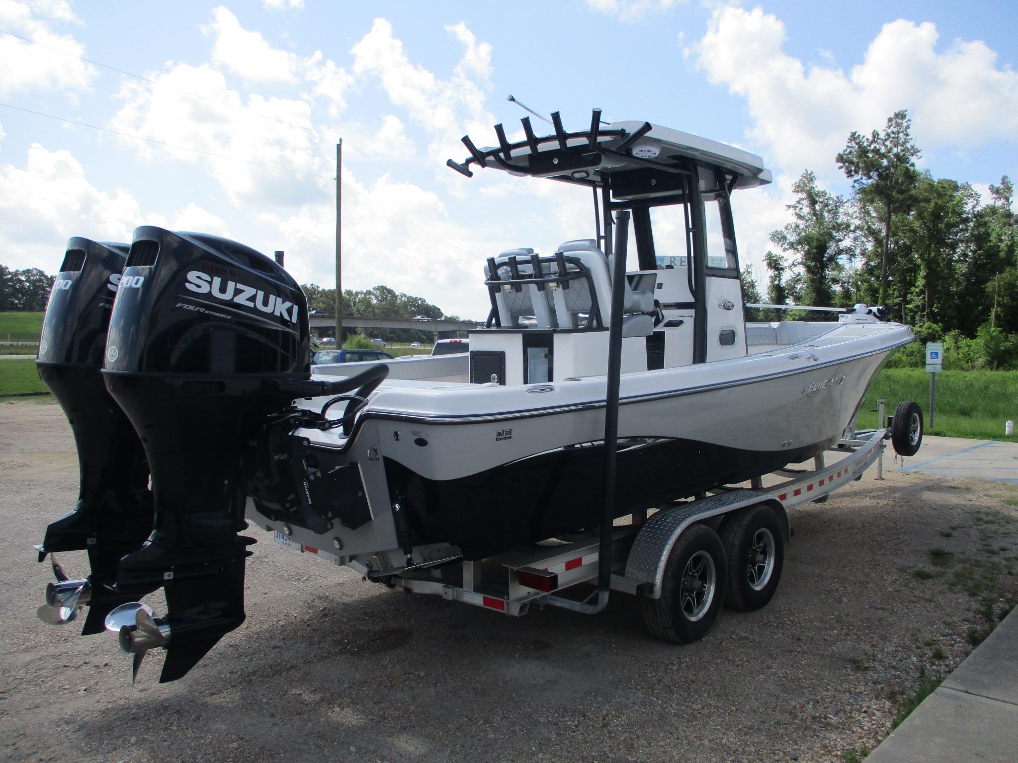 2024 Blue Wave 2800 Makaira boat with dual Suzuki engines on a trailer.