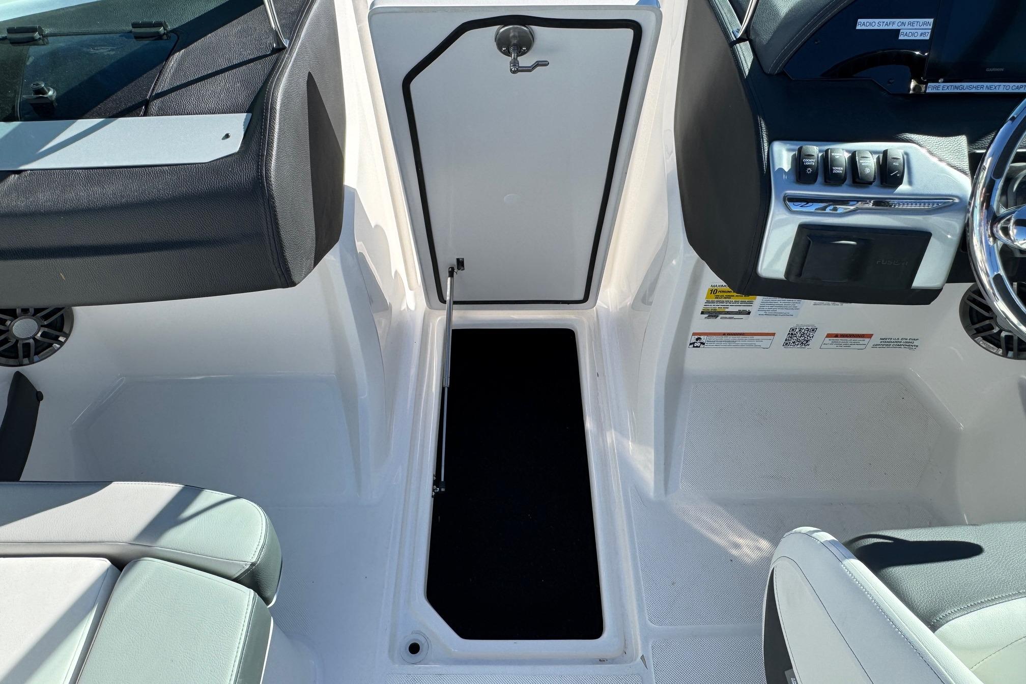 2026 Regal 21 OBX boat interior with open storage compartment and control panel.