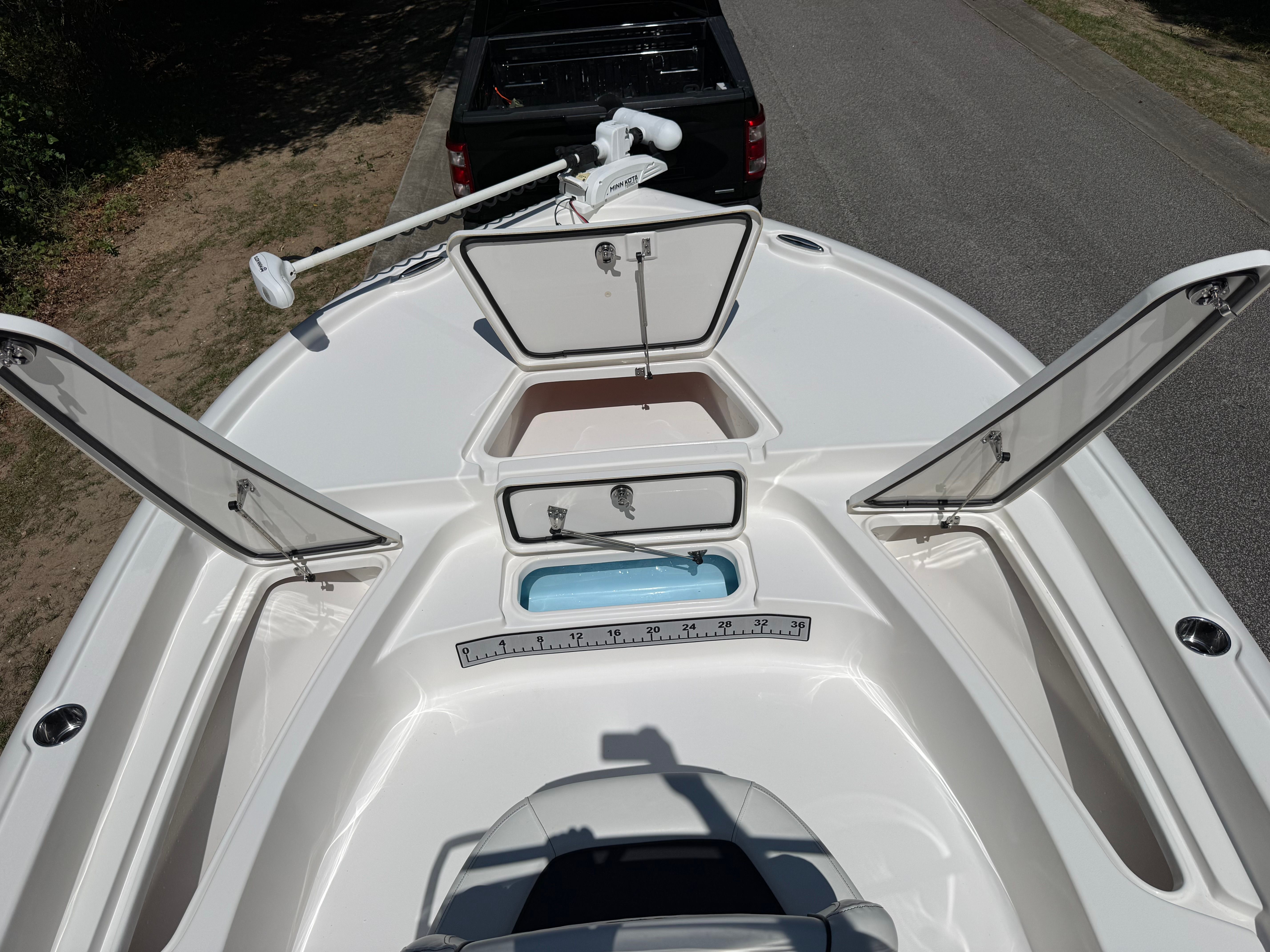 The image shows the bow of a Tidewater 2210 Carolina Bay boat with open storage compartments.
