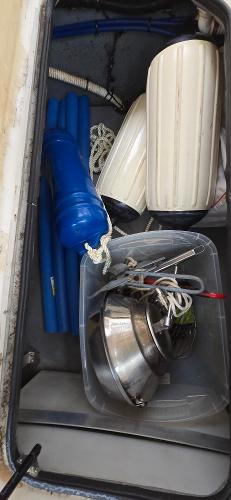Storage compartment of a 1999 Sea Ray 280 SS boat with fenders and equipment.