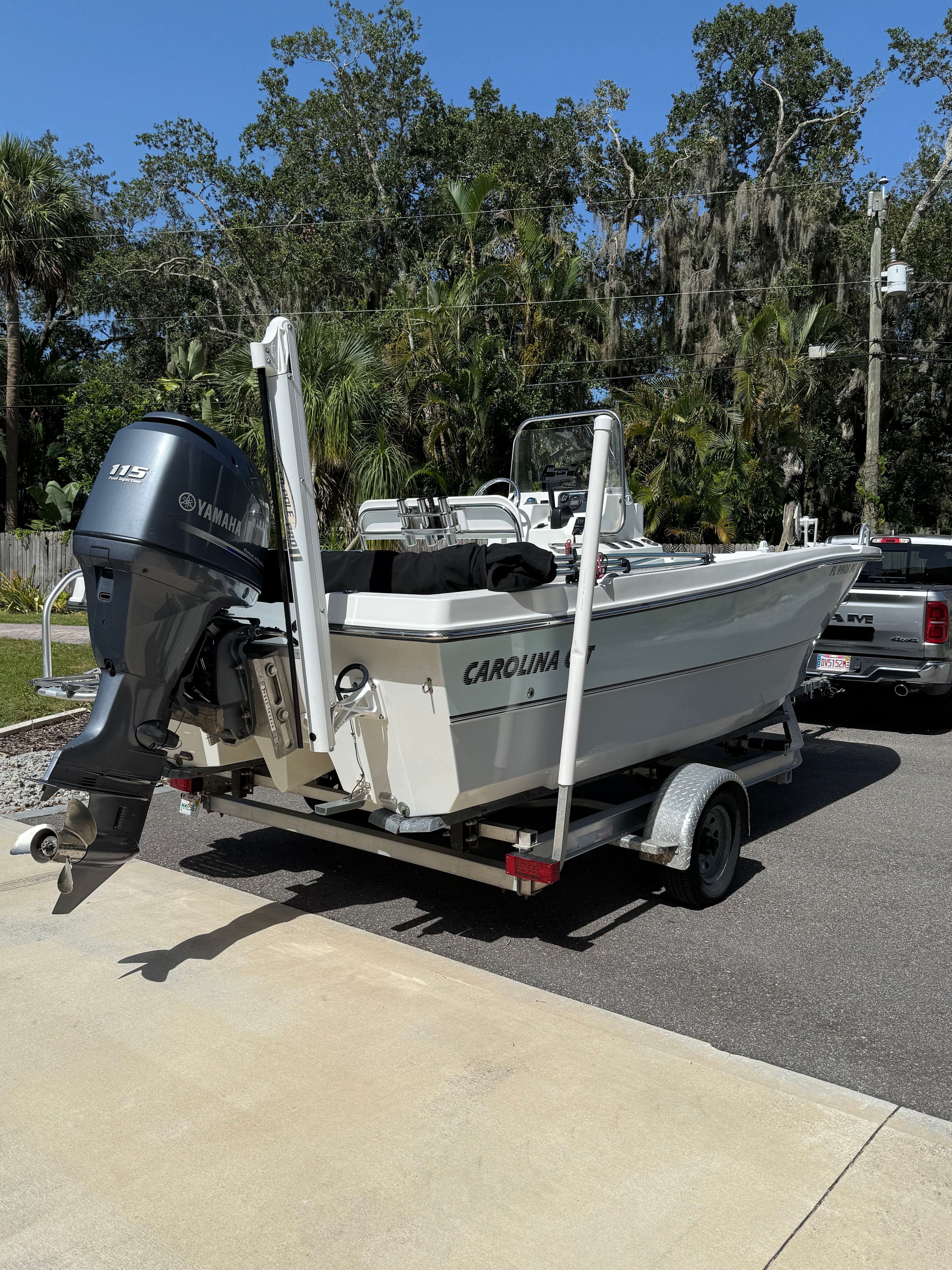 A Carolina Cat 18CC boat on a trailer, parked on a driveway.