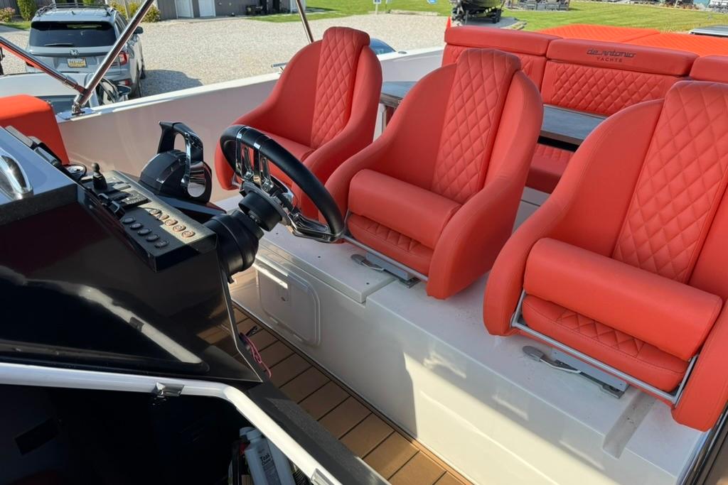 Red leather seats on 2020 De Antonio Yachts D28 boat, featuring modern steering controls.