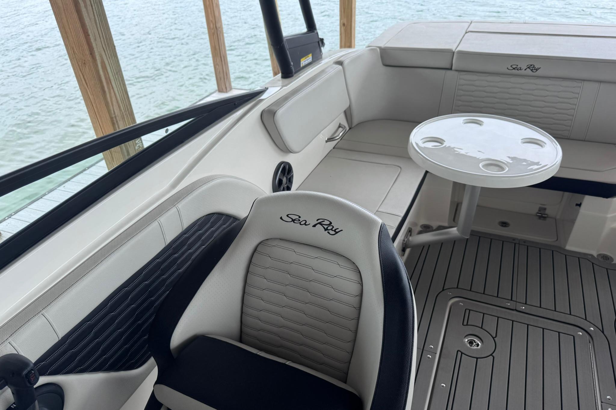 2021 Sea Ray SPX 230 boat interior with seating and table, dockside view.