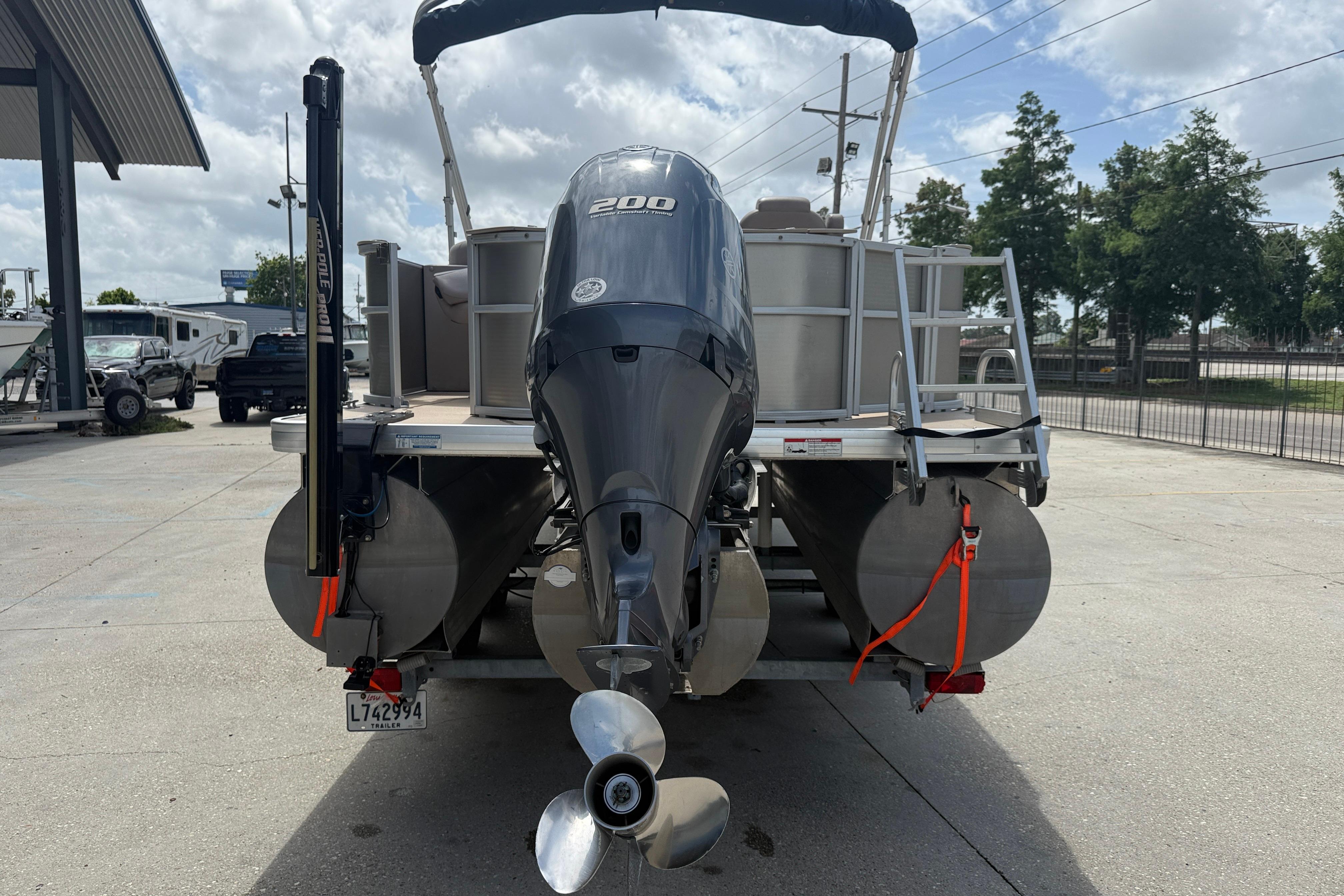 2014 Godfrey Sweetwater 2486 C pontoon boat with 200 HP engine, parked outdoors.