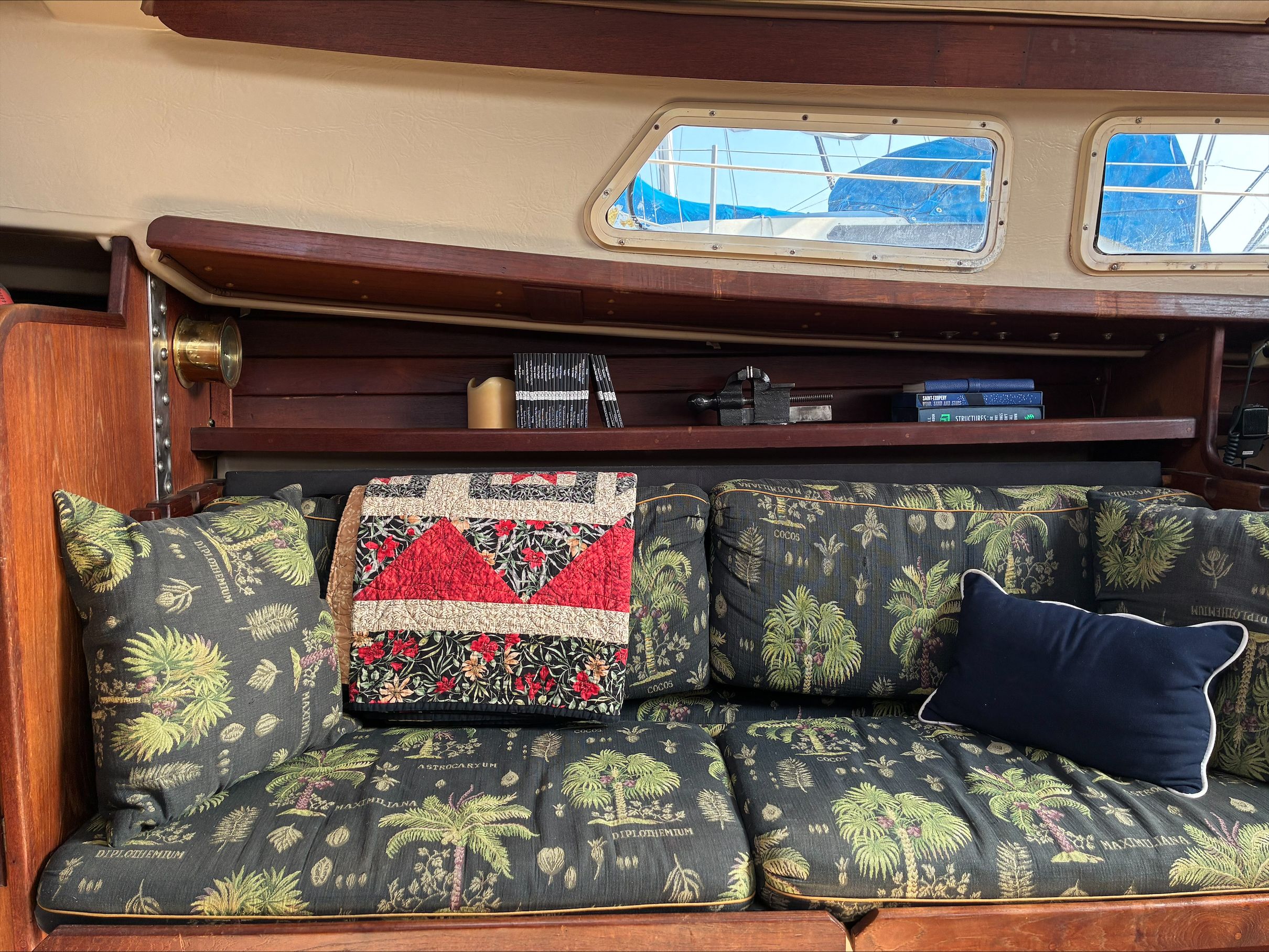 Interior of a 1980 Newport 30 with a cozy sofa and decorative pillows.