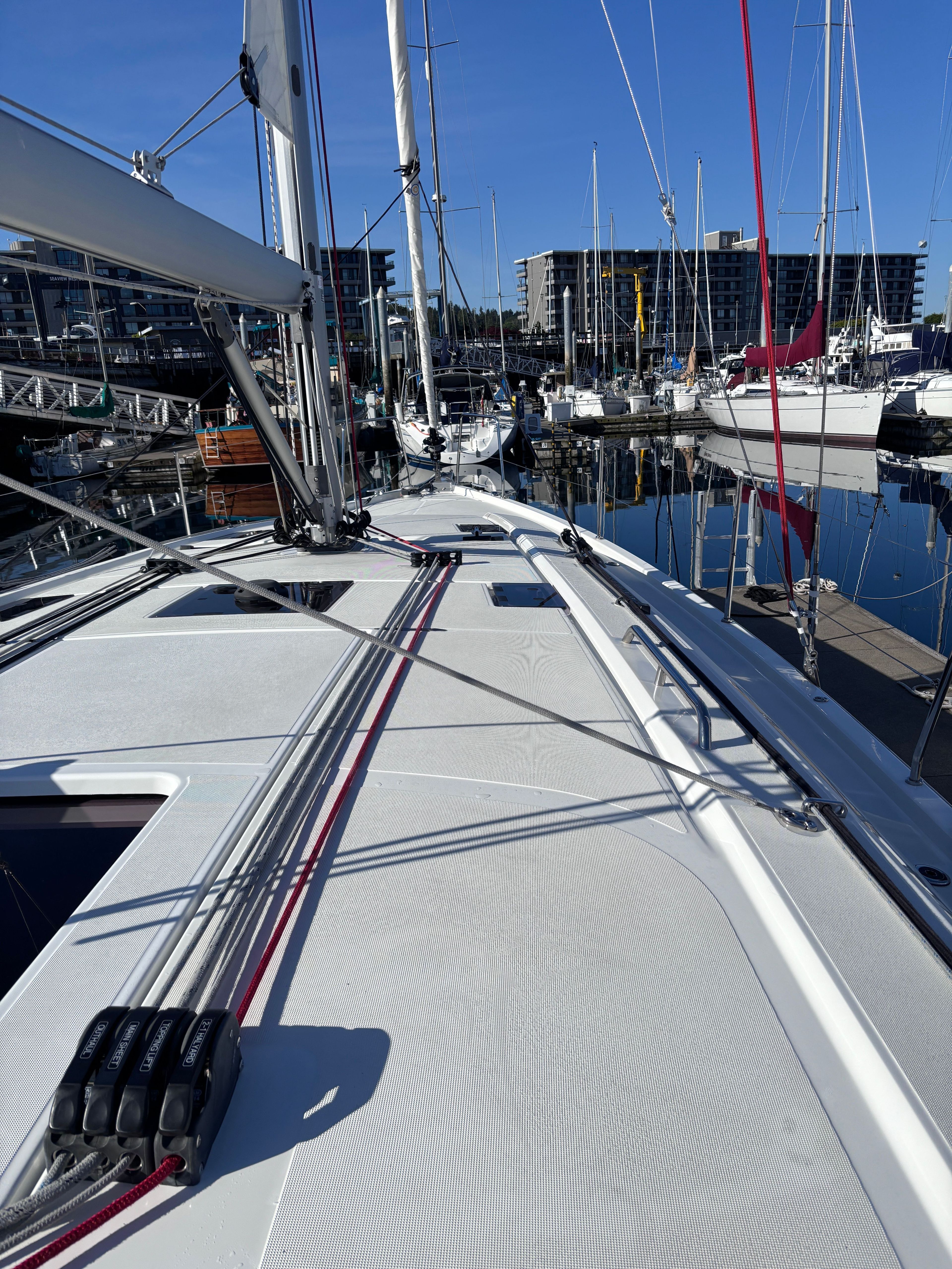 The deck of a Beneteau Oceanis 40.1 in a marina, surrounded by other boats.