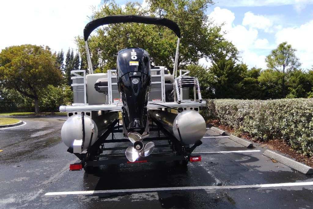 2026 Sun Tracker Fishin' Barge 22 DLX pontoon boat with powerful outboard motor.
