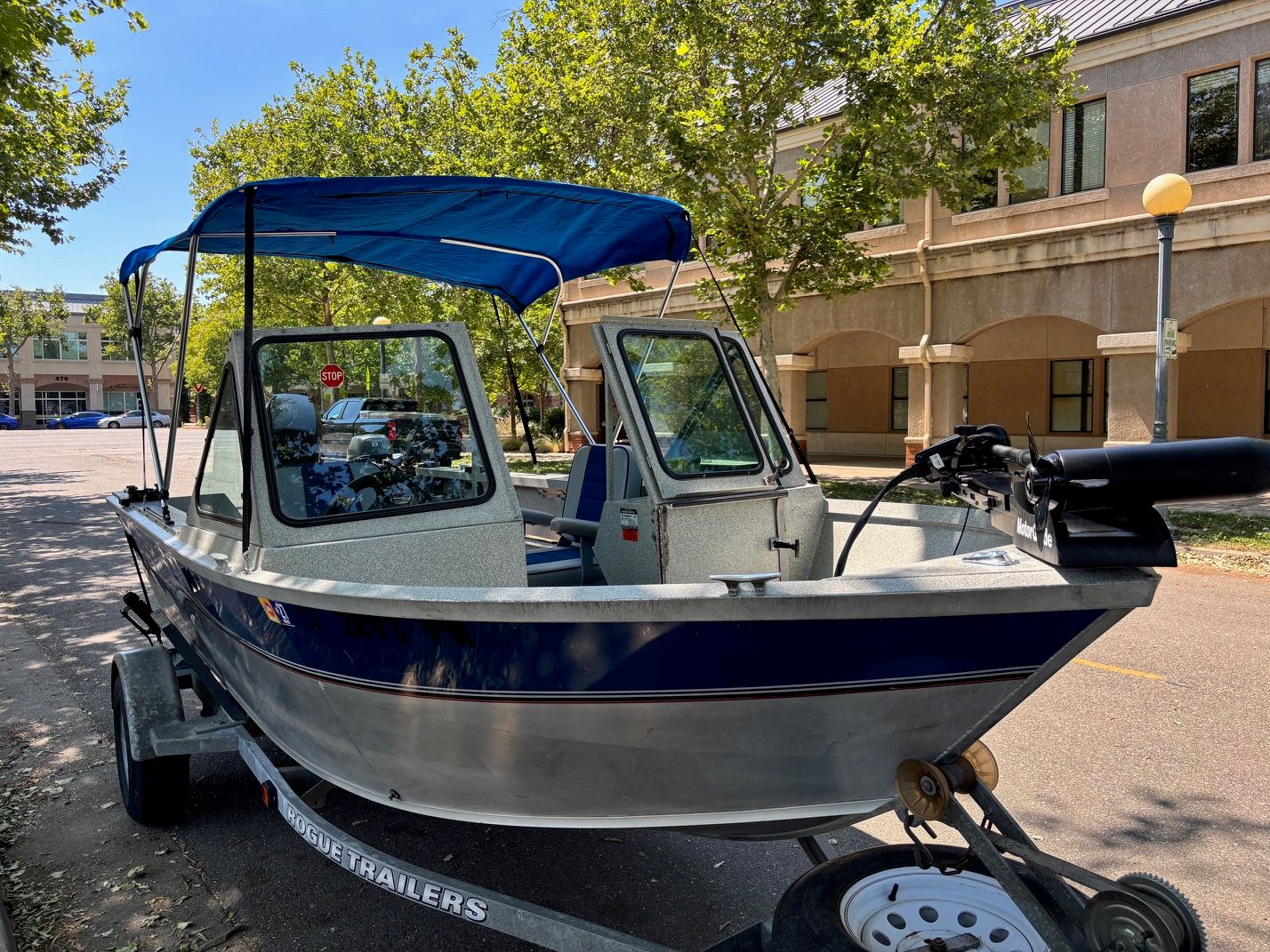 A 2002 Stryker Rogue boat on a trailer in an urban setting.