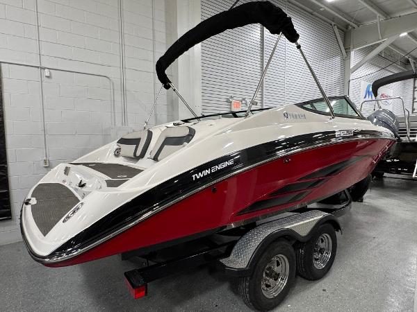 2014 Yamaha Boats 212X, red and white, twin engine, on trailer in showroom.