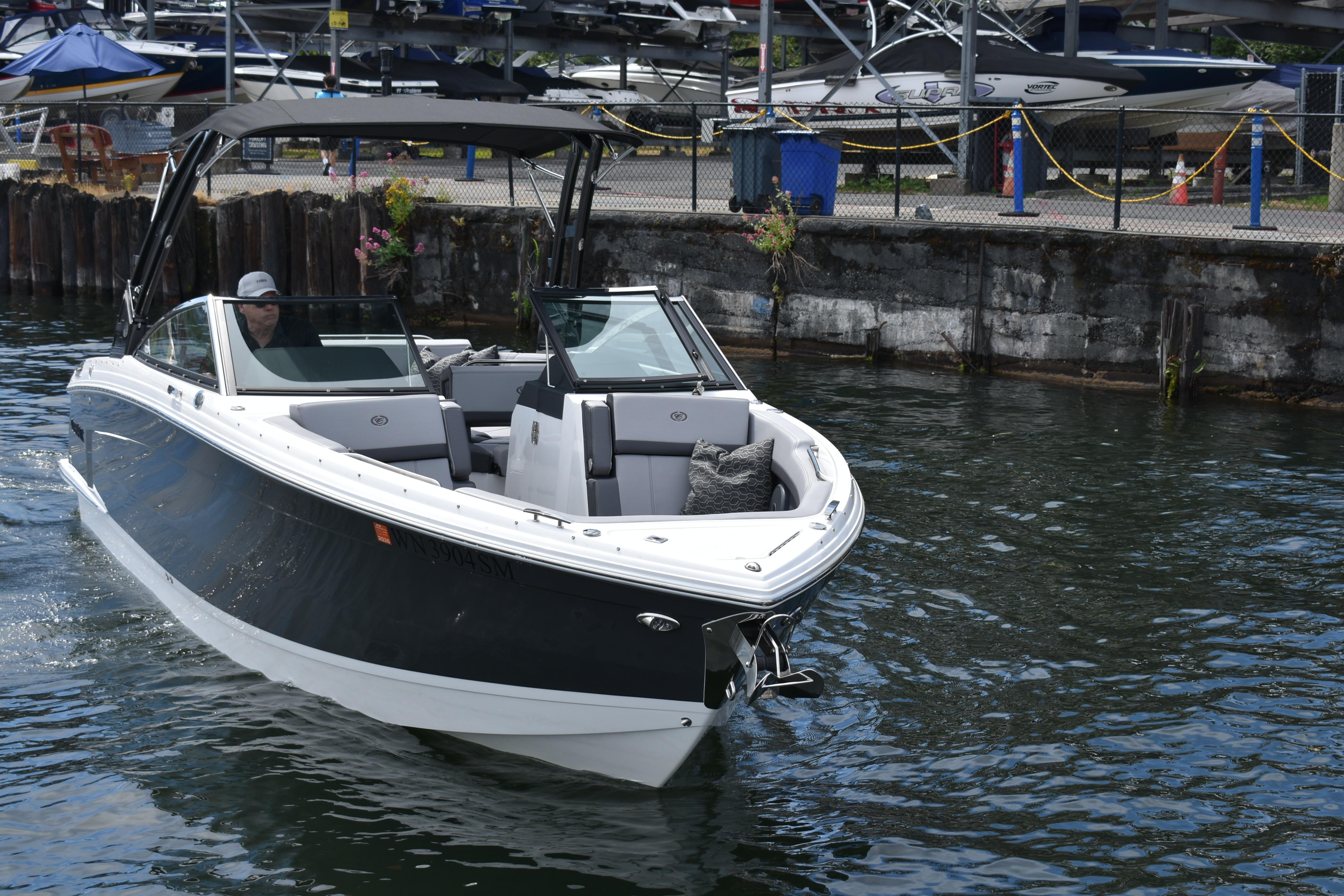 2023 Cobalt R8 boat cruising near a dock, showcasing sleek design and luxury features.