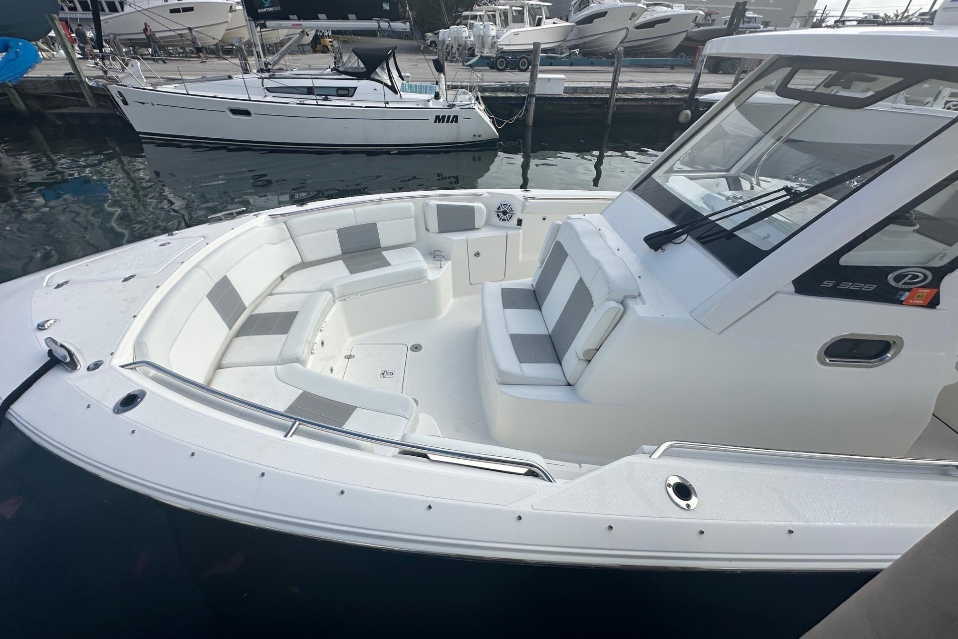 2023 Pursuit S 328 Sport boat with spacious seating at a marina.