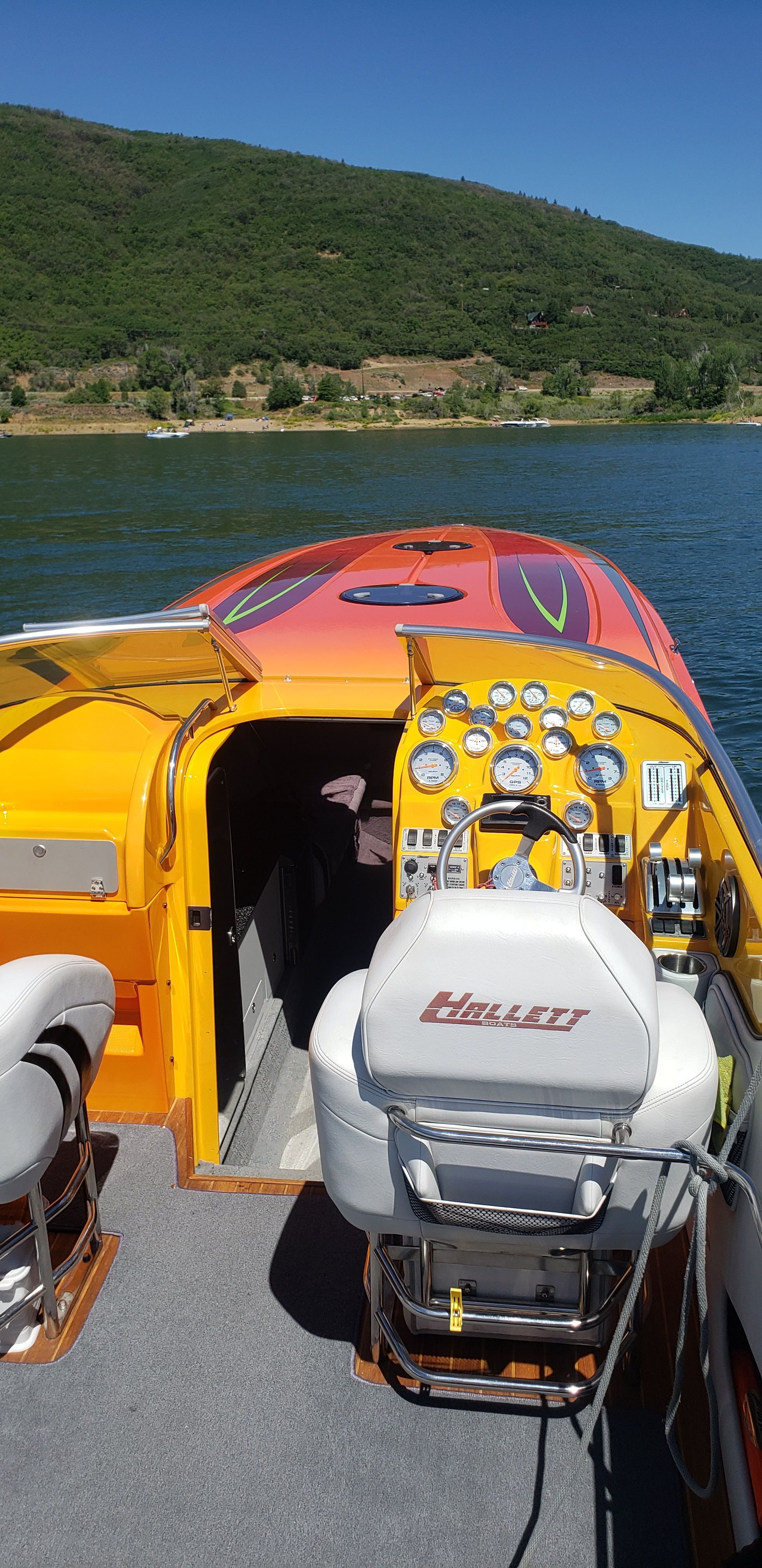 2009 Hallett 400T boat on a lake with green hills.