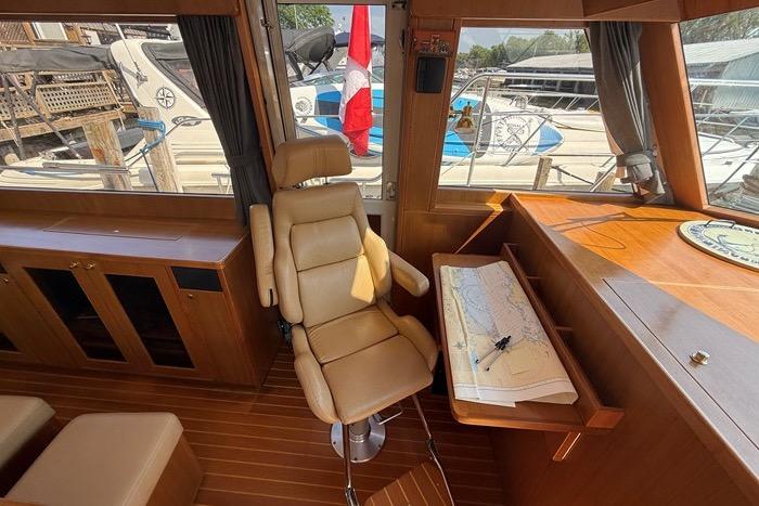 Pilot house interior of 2007 Island Pilot 395 with navigation chart and chair.