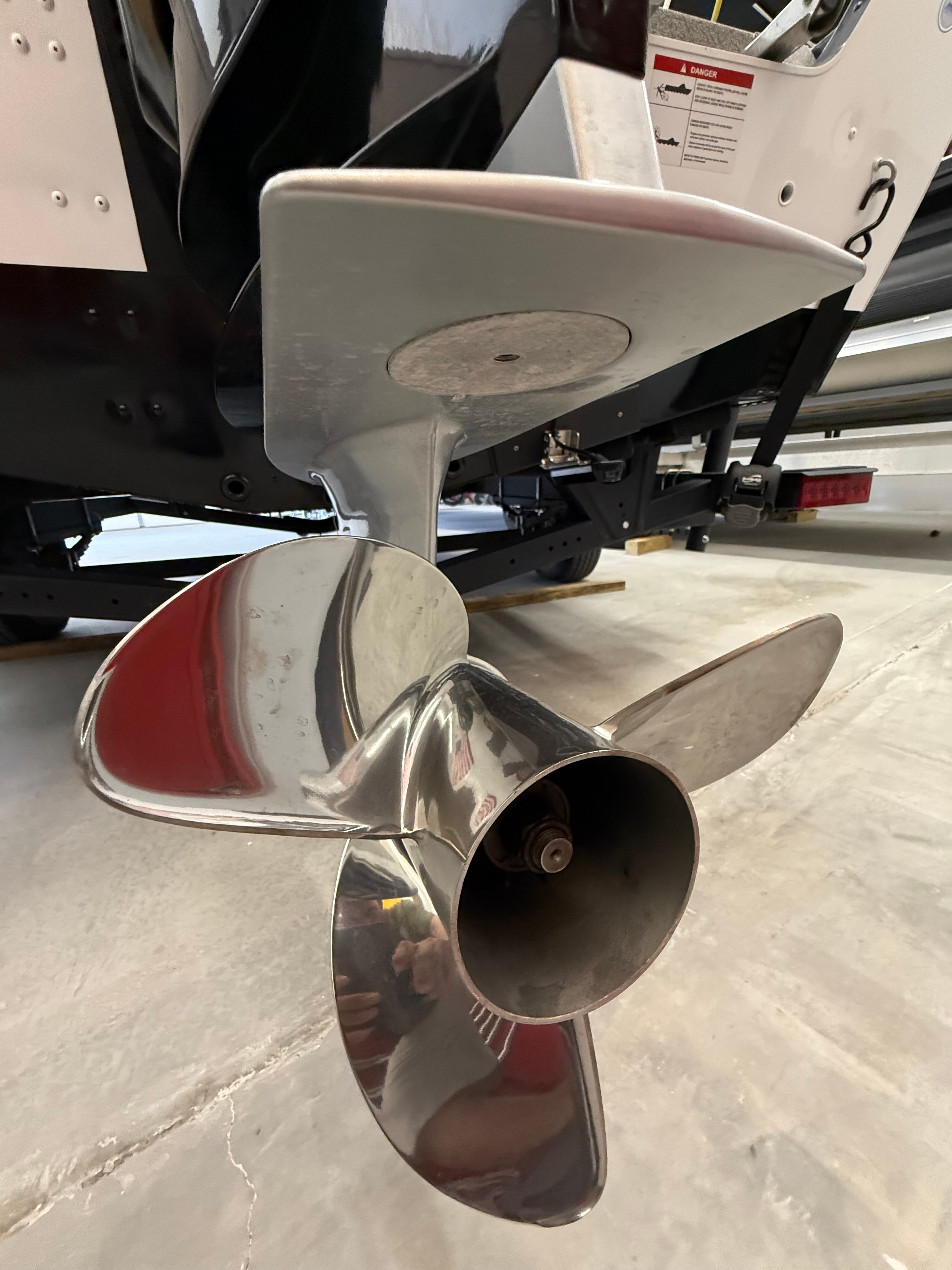 Close-up of a shiny propeller on a boat, situated in a garage.
