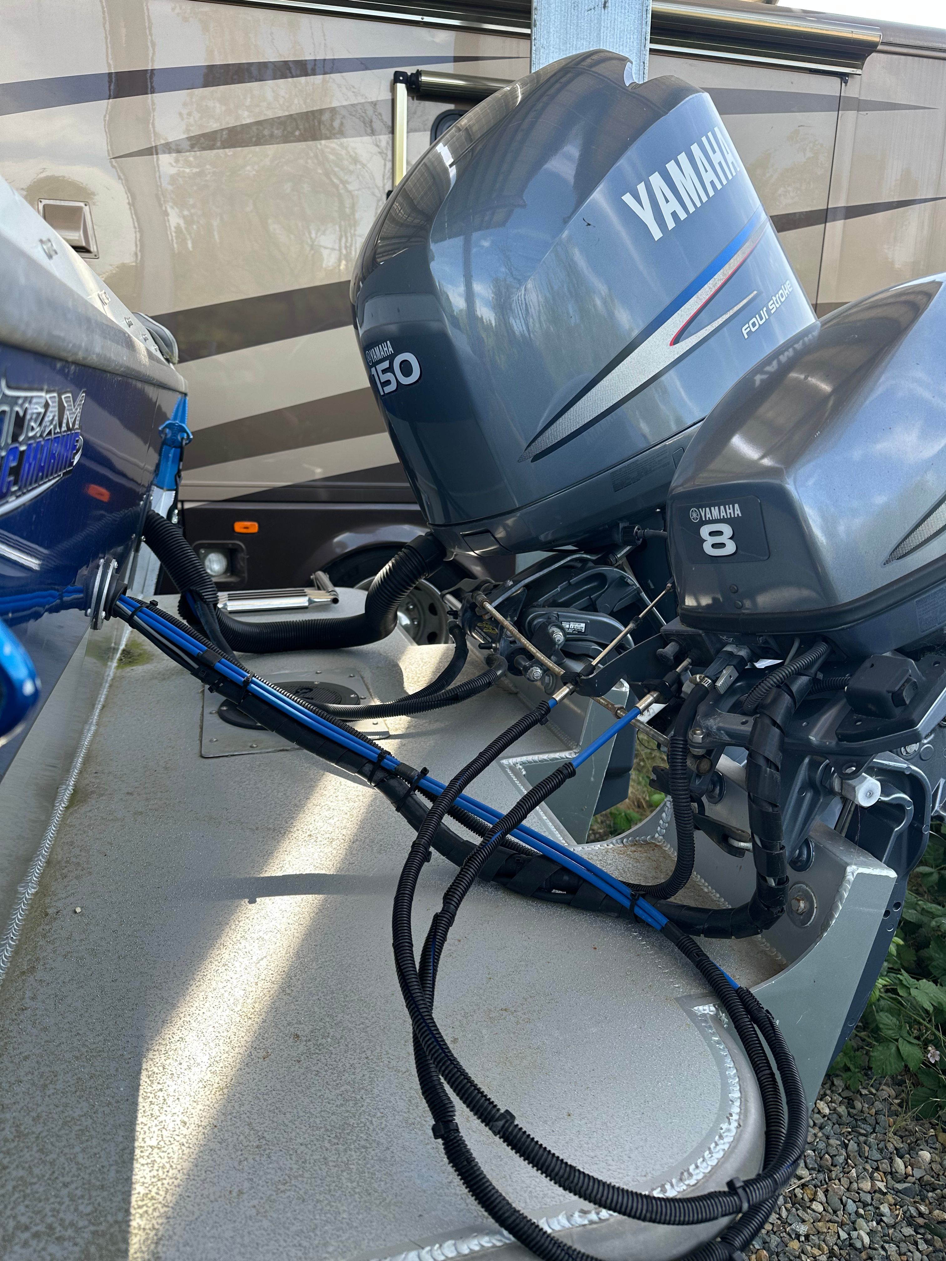 Two Yamaha outboard motors on a boat sitting on a trailer.