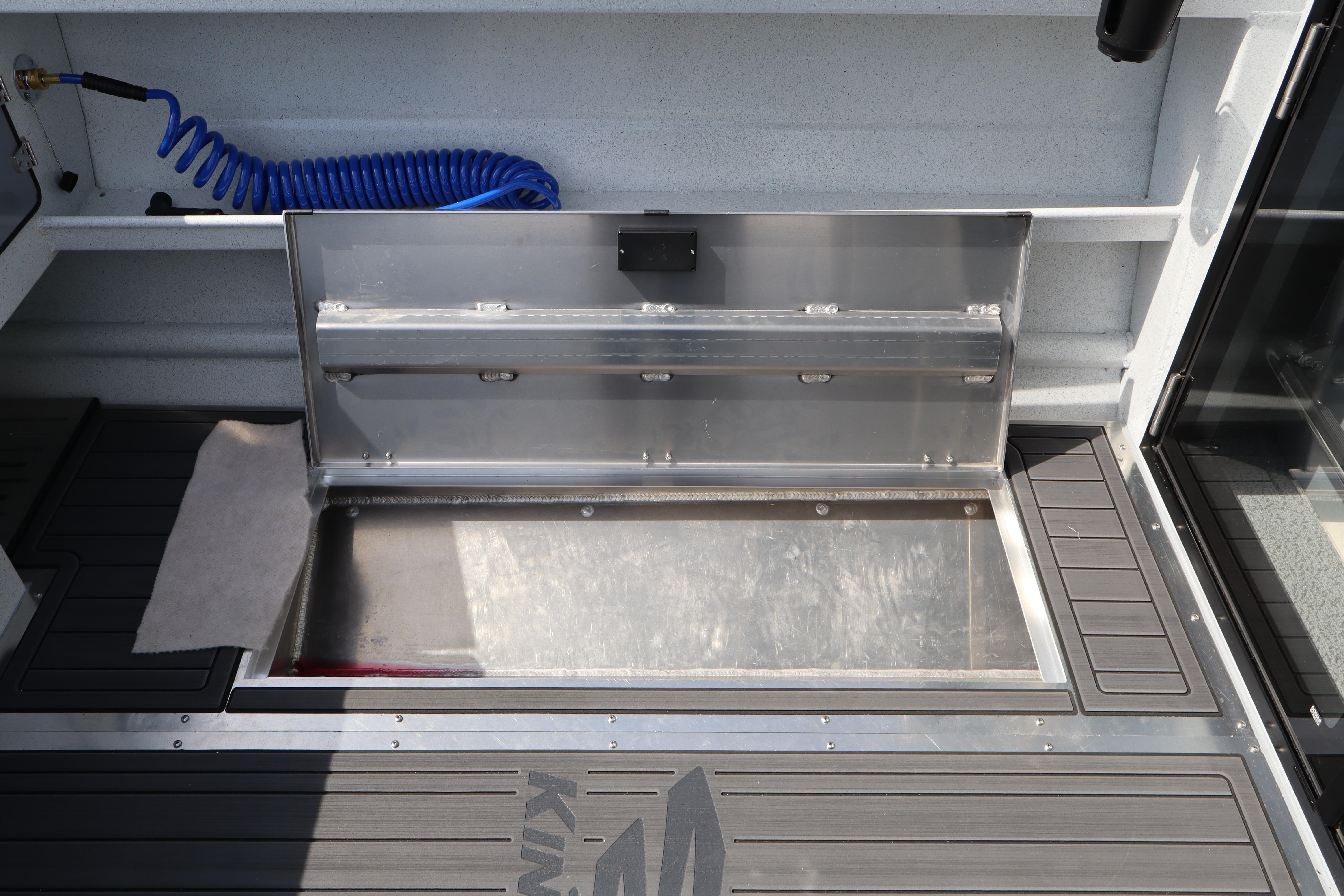 Open storage compartment on 2026 KingFisher 25 XAC boat deck with blue coiled hose.