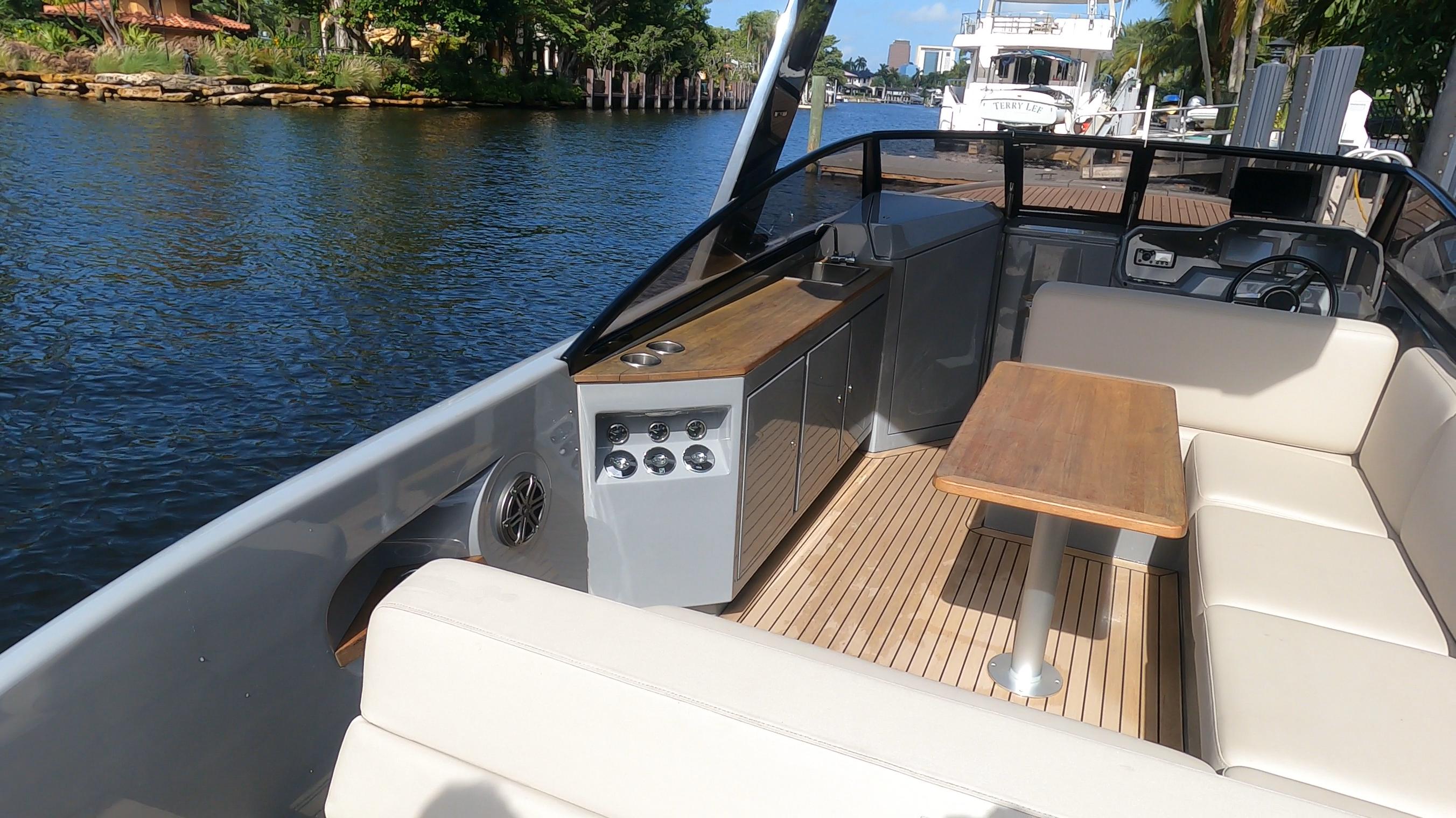 2021 Rand Leisure boat interior with seating and table on a sunny day.