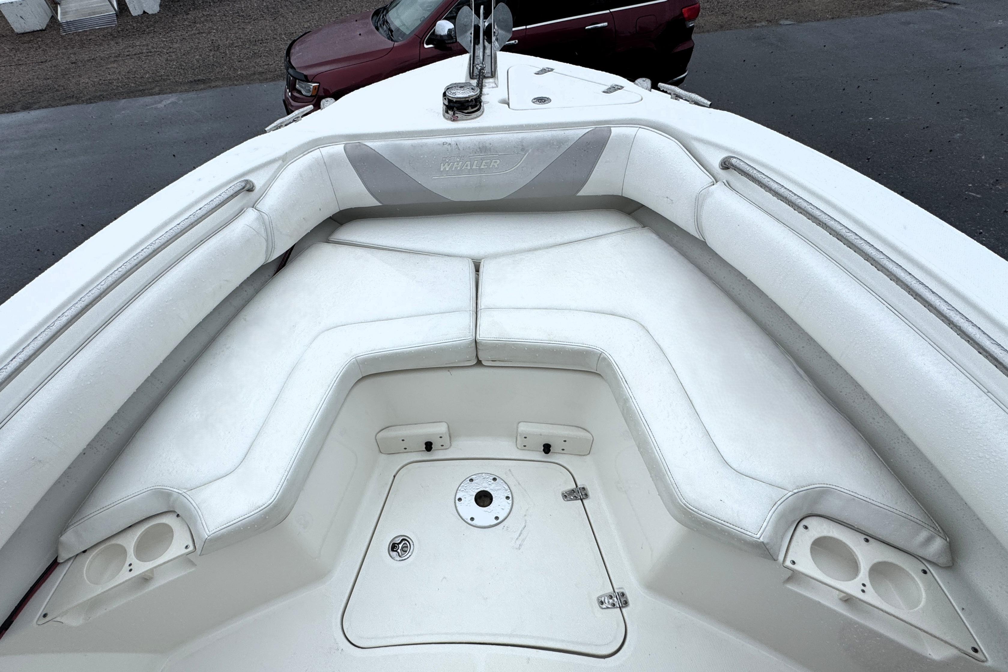 2014 Boston Whaler 250 Outrage boat interior with white cushioned seating and storage compartments.