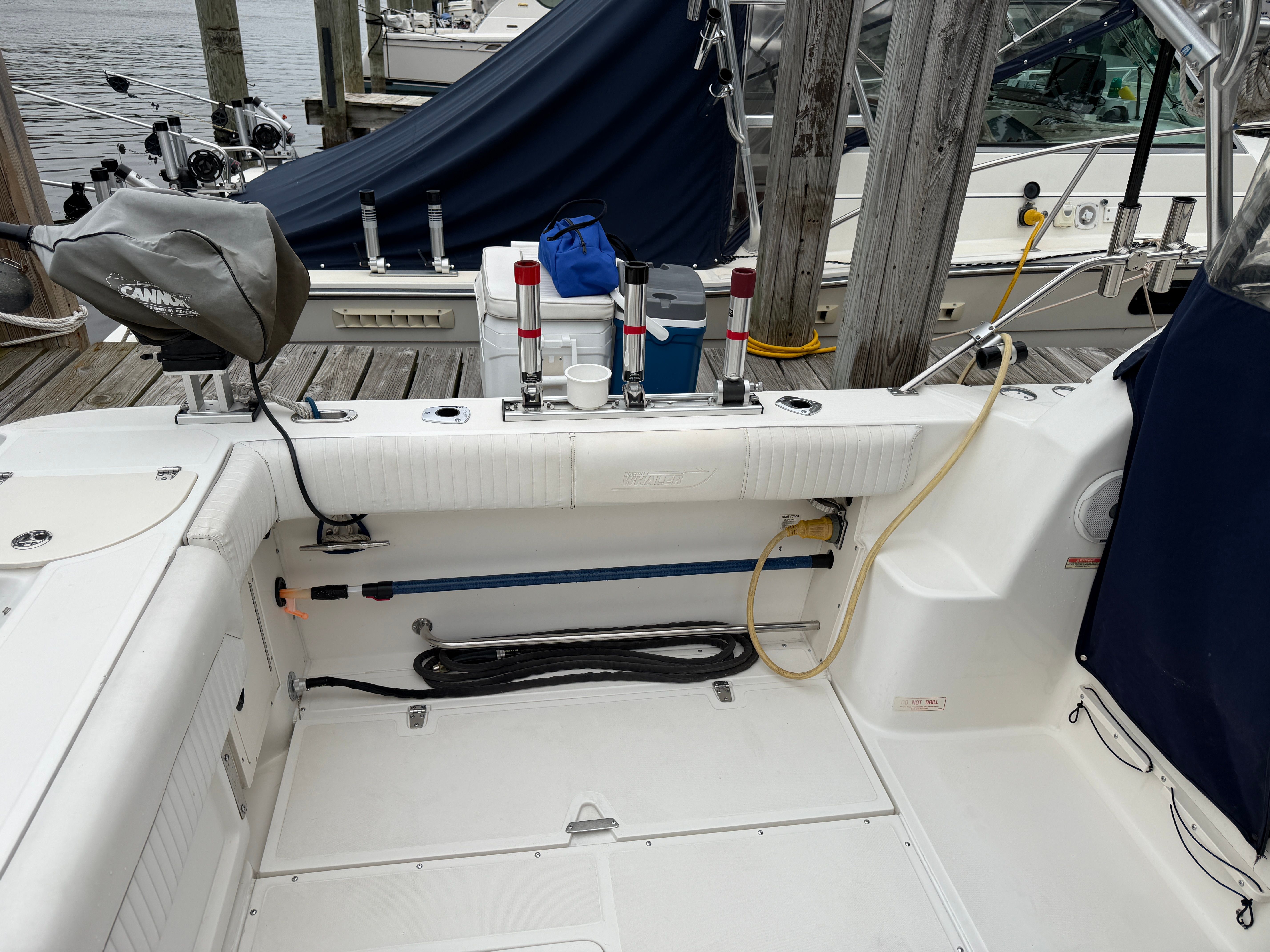 The image shows the cockpit of a 2001 Boston Whaler 26 Conquest docked at a pier.