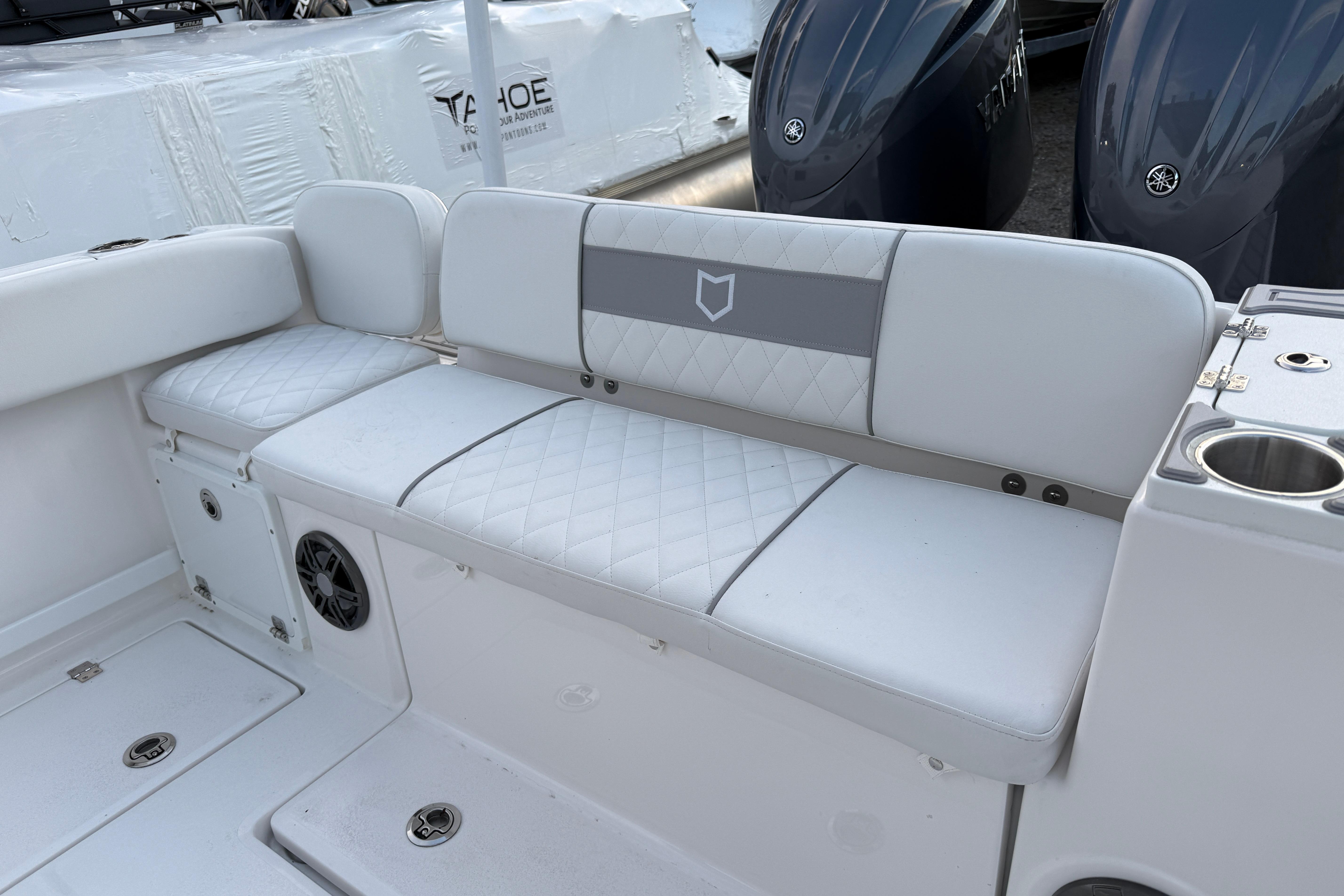 2026 Sea Fox 268 Commander boat seating area with white cushioned seats and cup holders.