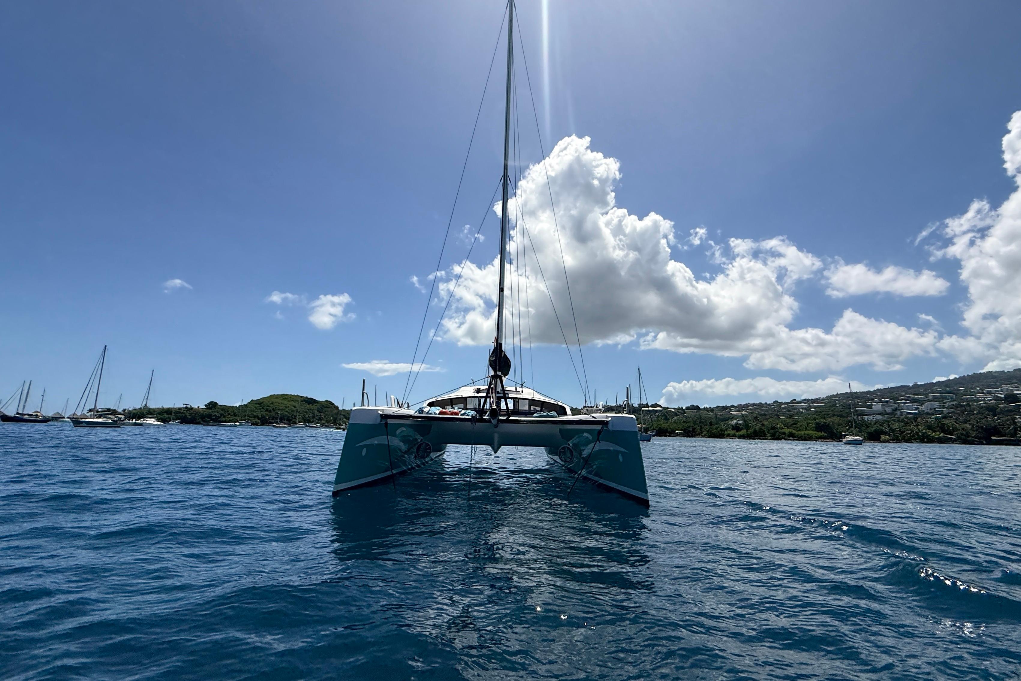 Sailing catamaran Marsaudon Composites ORC 42, 2014, on calm blue waters under a clear sky.