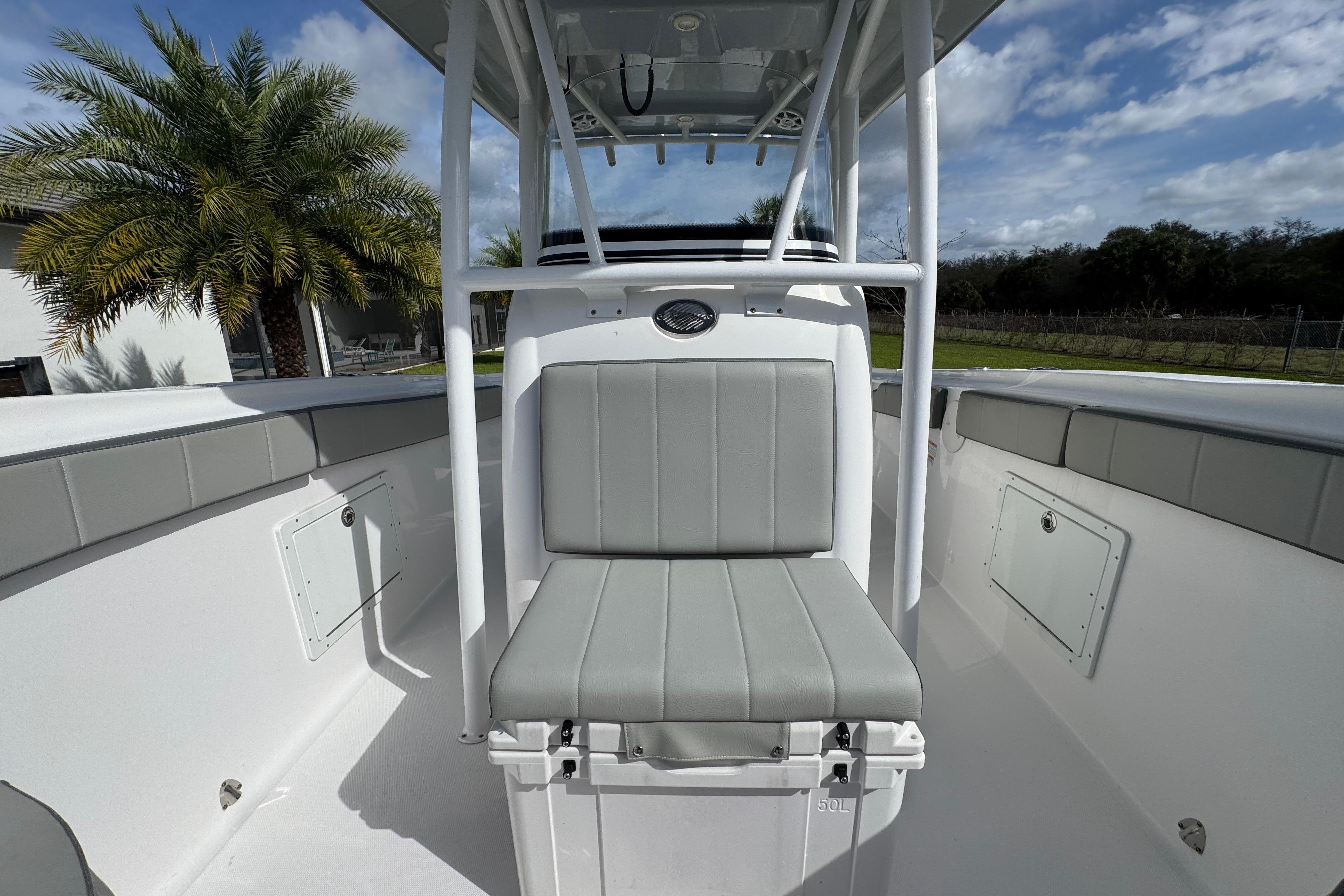 2022 Aquasport 2500 Center Console boat interior with seating, palm tree in background.