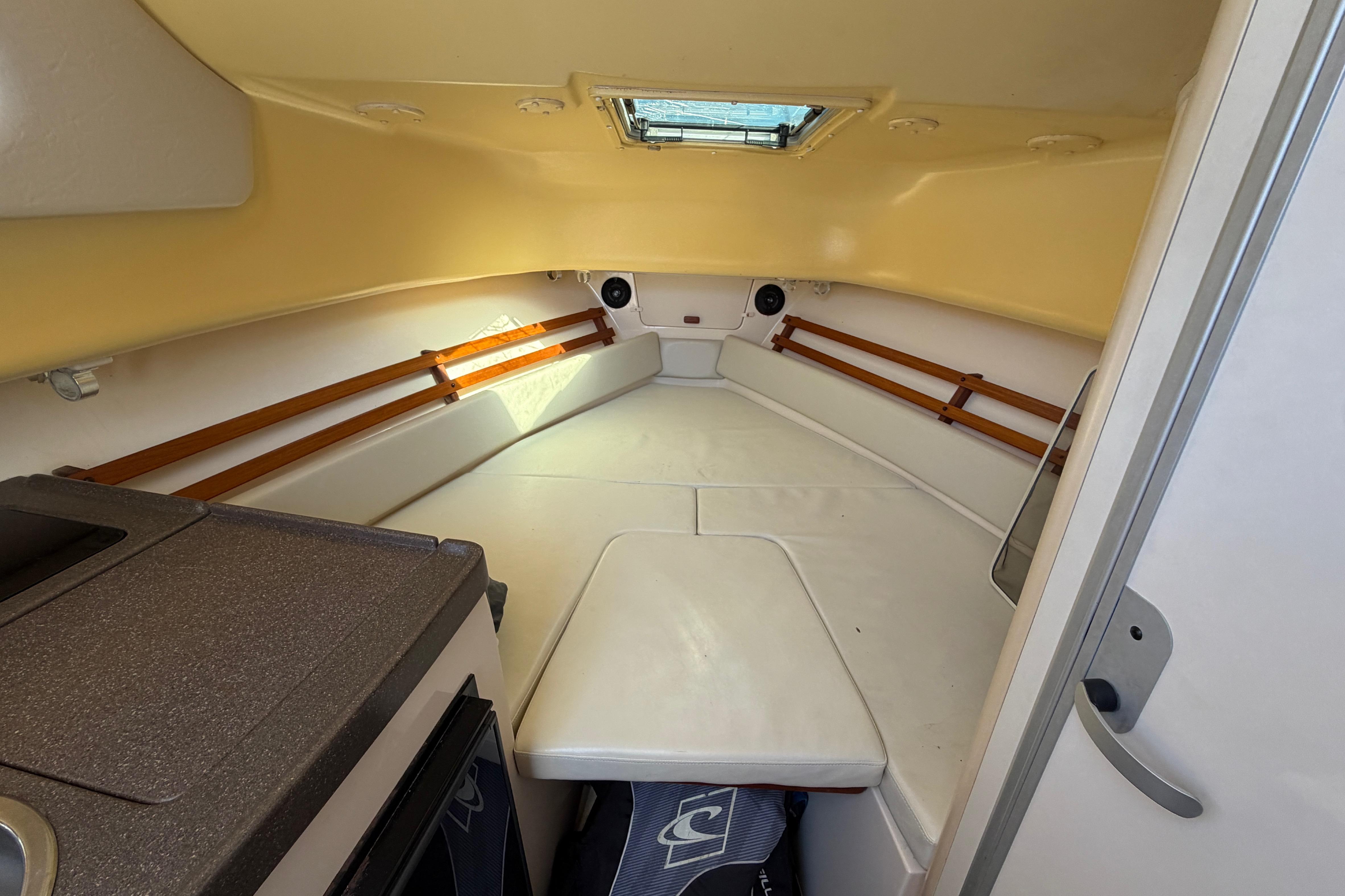 2006 Grady-White Sailfish 282 cabin interior with cushioned seating and compact kitchenette.