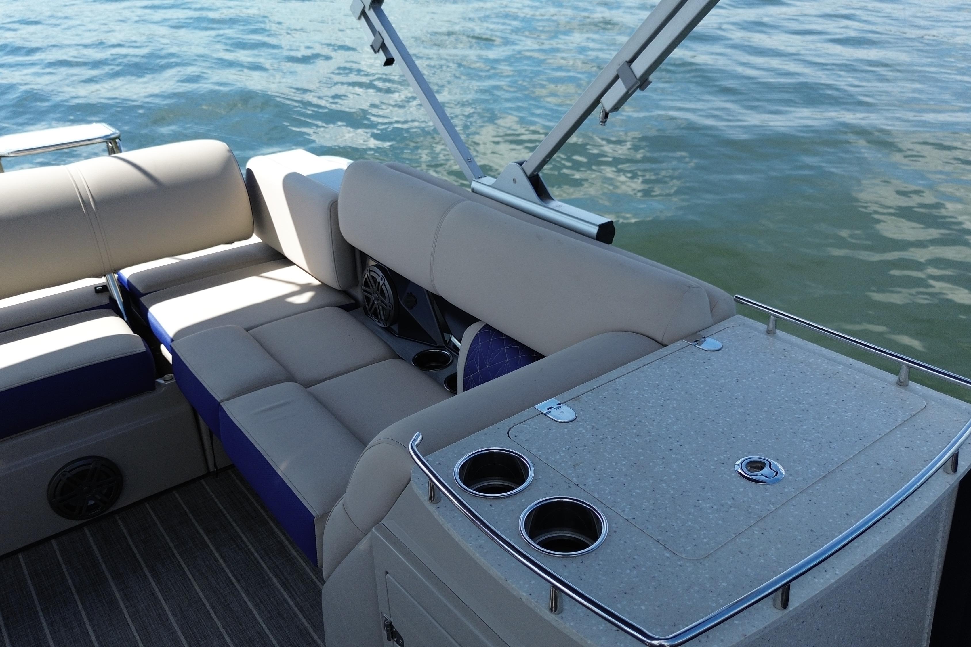 2022 Harris Grand Mariner 250 boat interior with seating and cup holders on water.