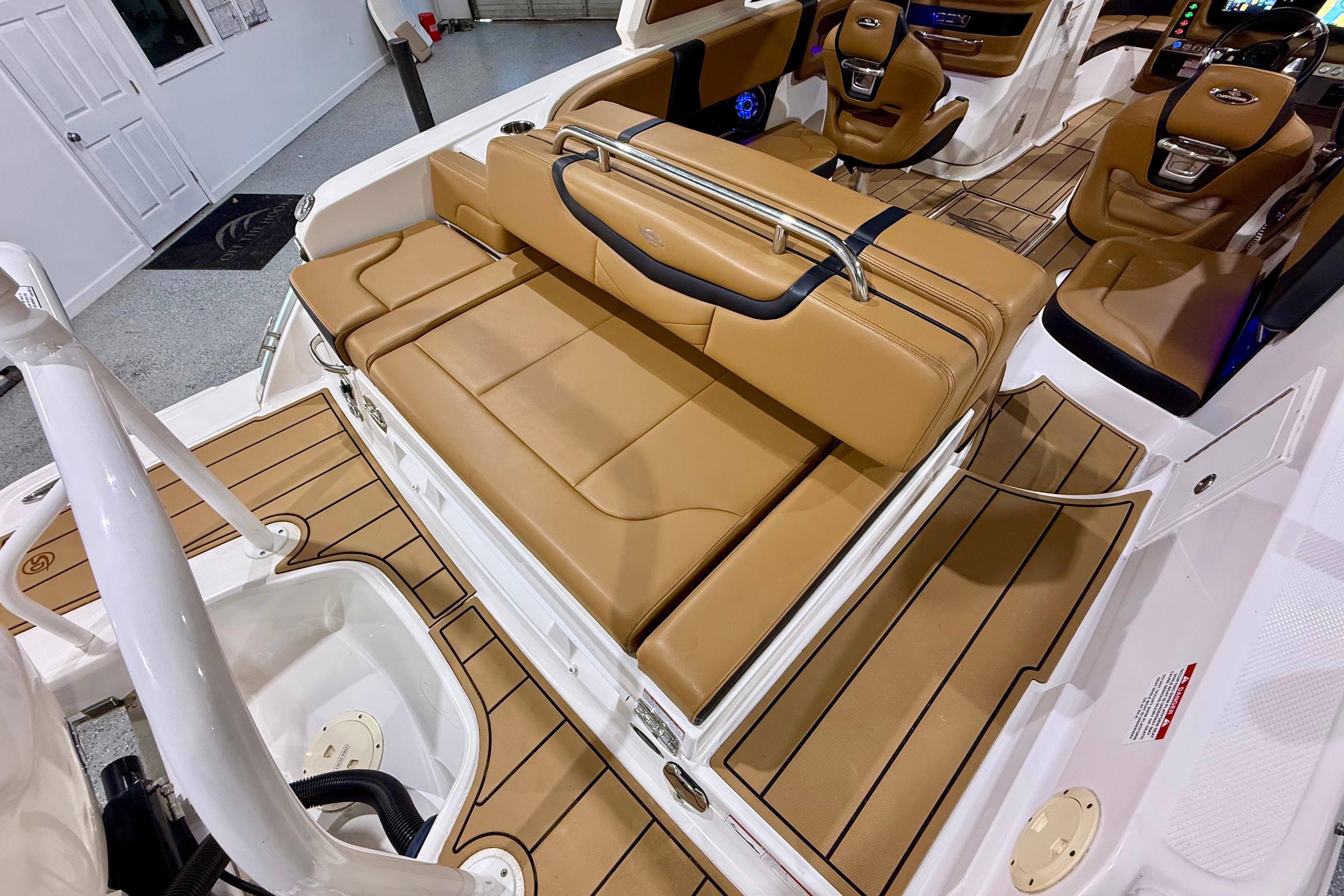 2023 Chaparral 270 OSX boat interior with tan leather seating and wood-style flooring.