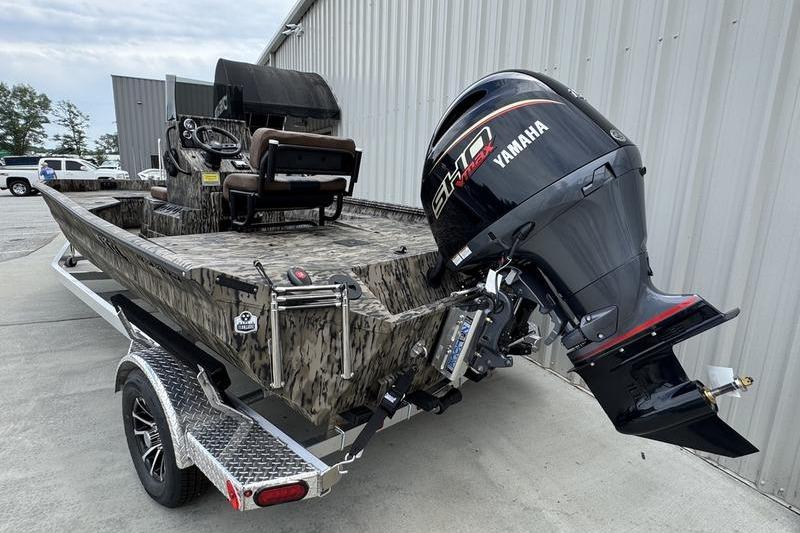 2027 Excel 230 Bay Pro Elite boat with Yamaha engine on trailer, parked outdoors.