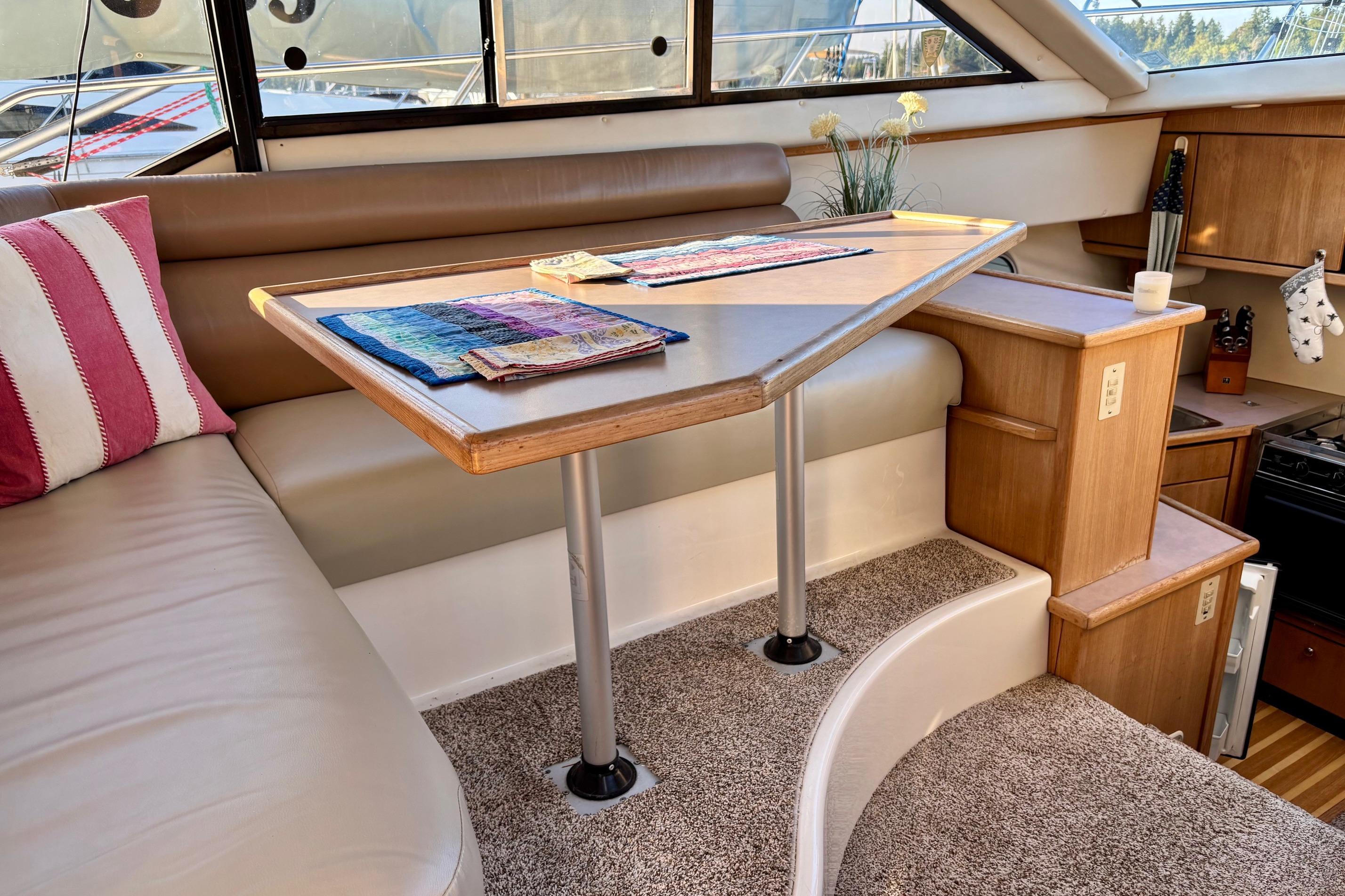 Interior of 1998 Bayliner 3388 Command Bridge Motoryacht with cozy seating and table.