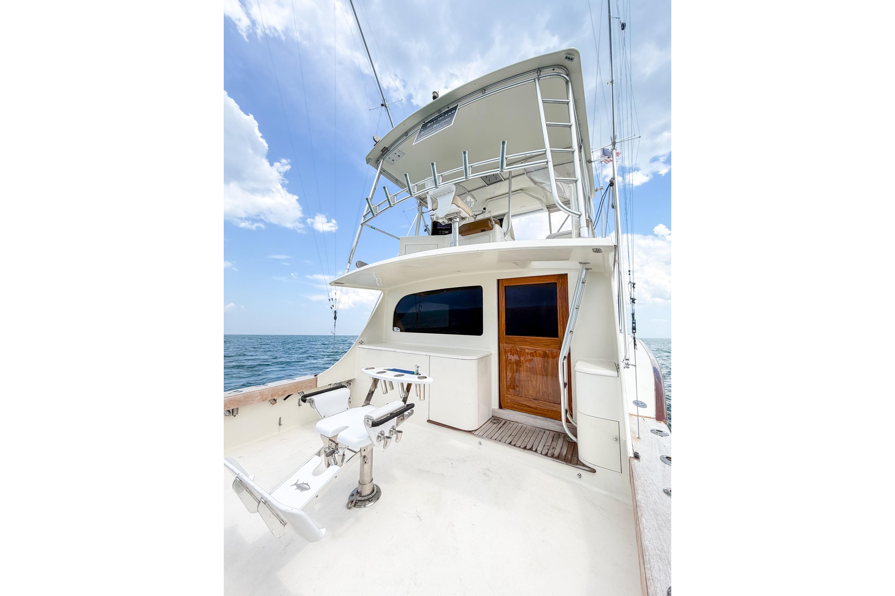 1998 Blackwell Custom Carolina Sportfish yacht with fishing chair, ocean backdrop, and clear sky.