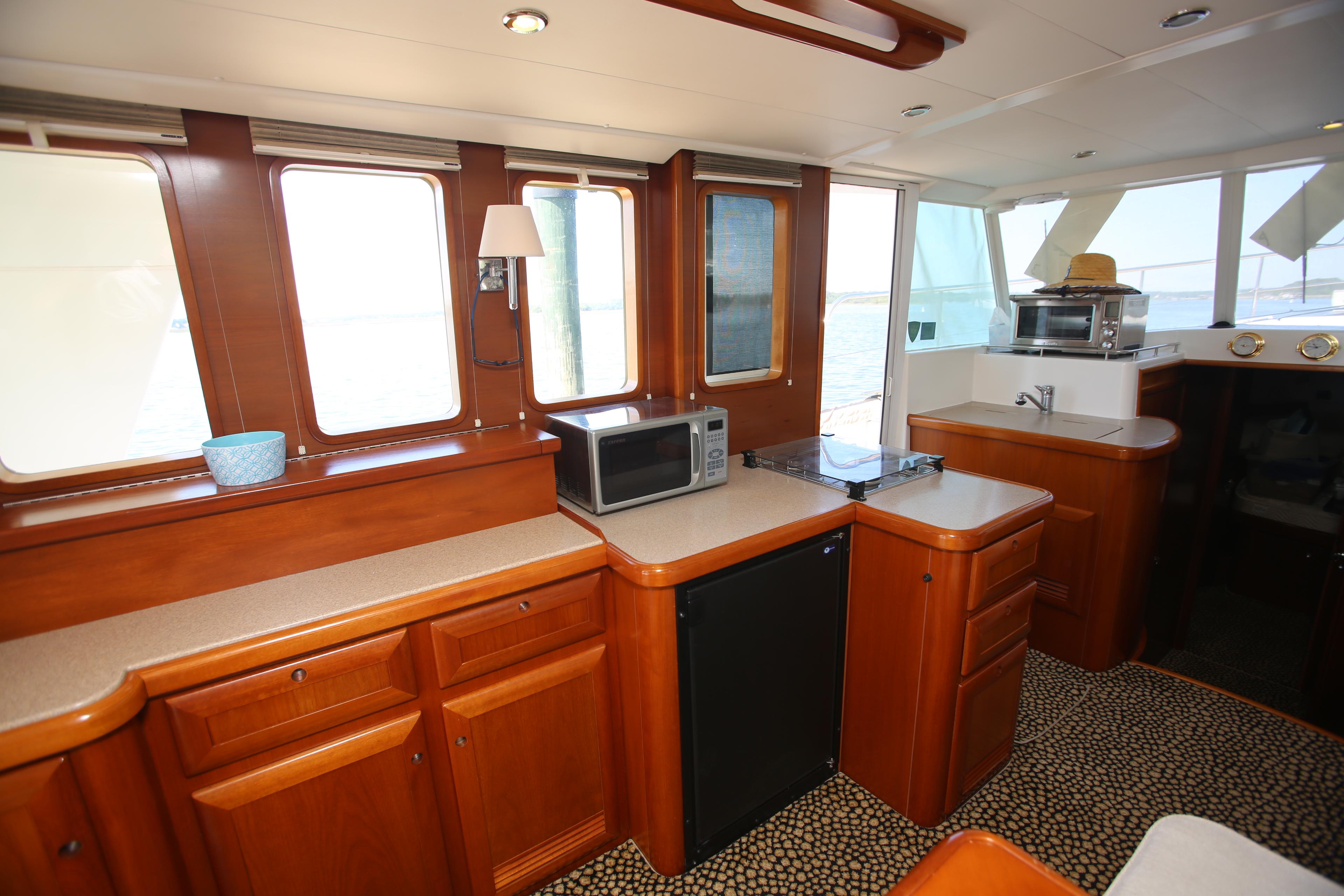 Interior of 2007 Beneteau Swift Trawler 42 with kitchen appliances and wooden cabinetry.