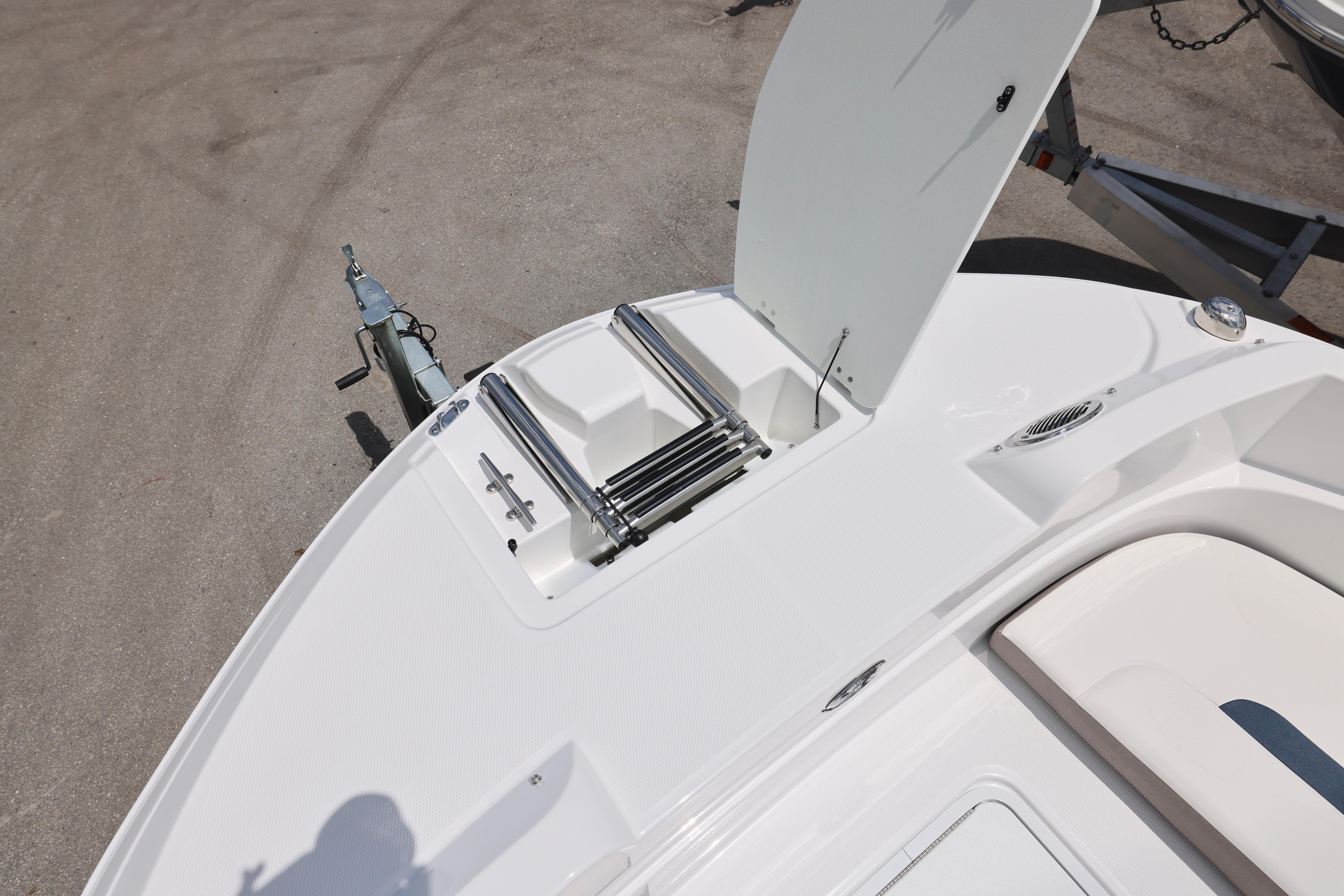 2026 Hurricane SunDeck Sport 205 OB boat with open storage compartment and ladder.