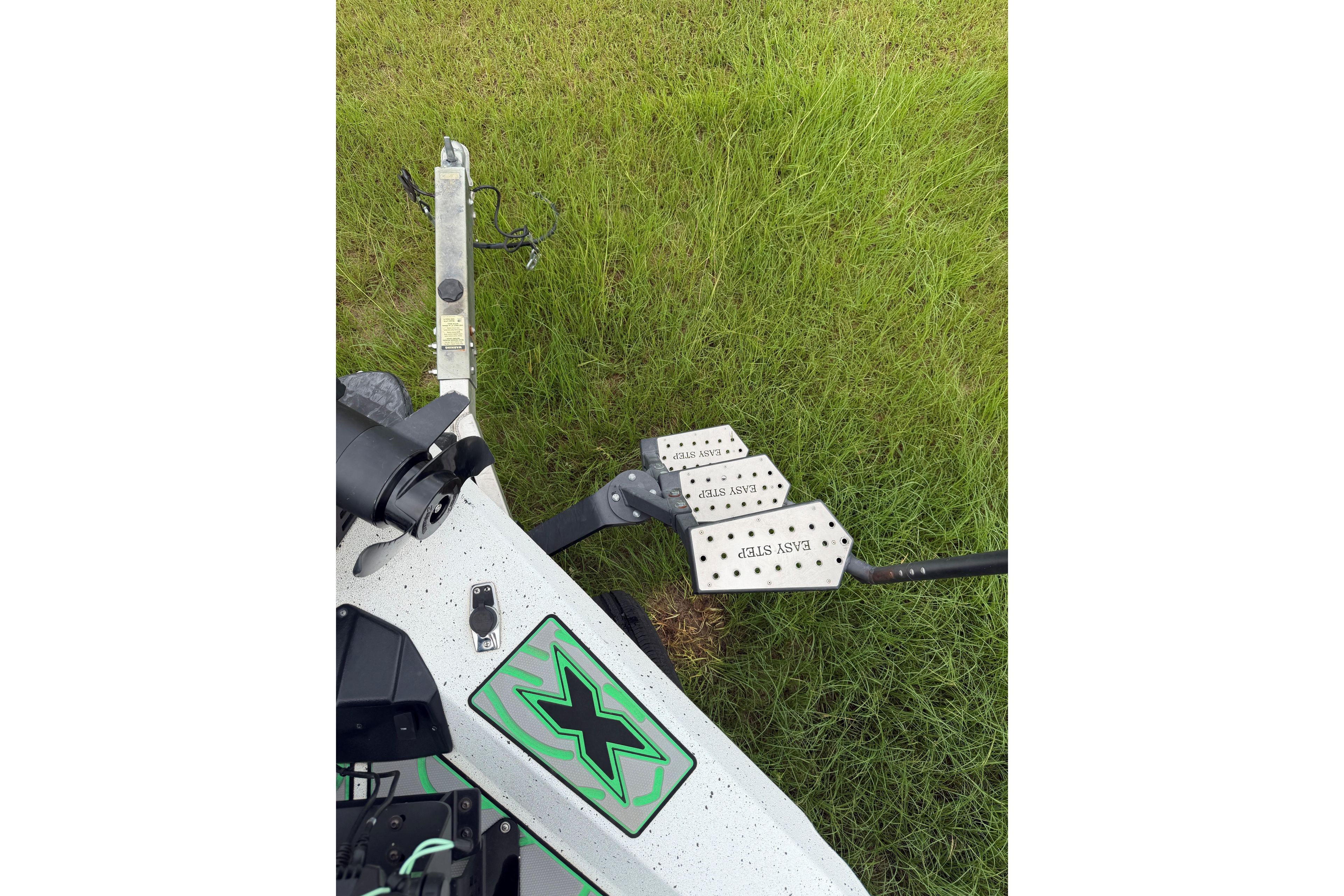 Xpress X21 Pro 2022 boat trailer with "Easy Step" feature on grassy background.