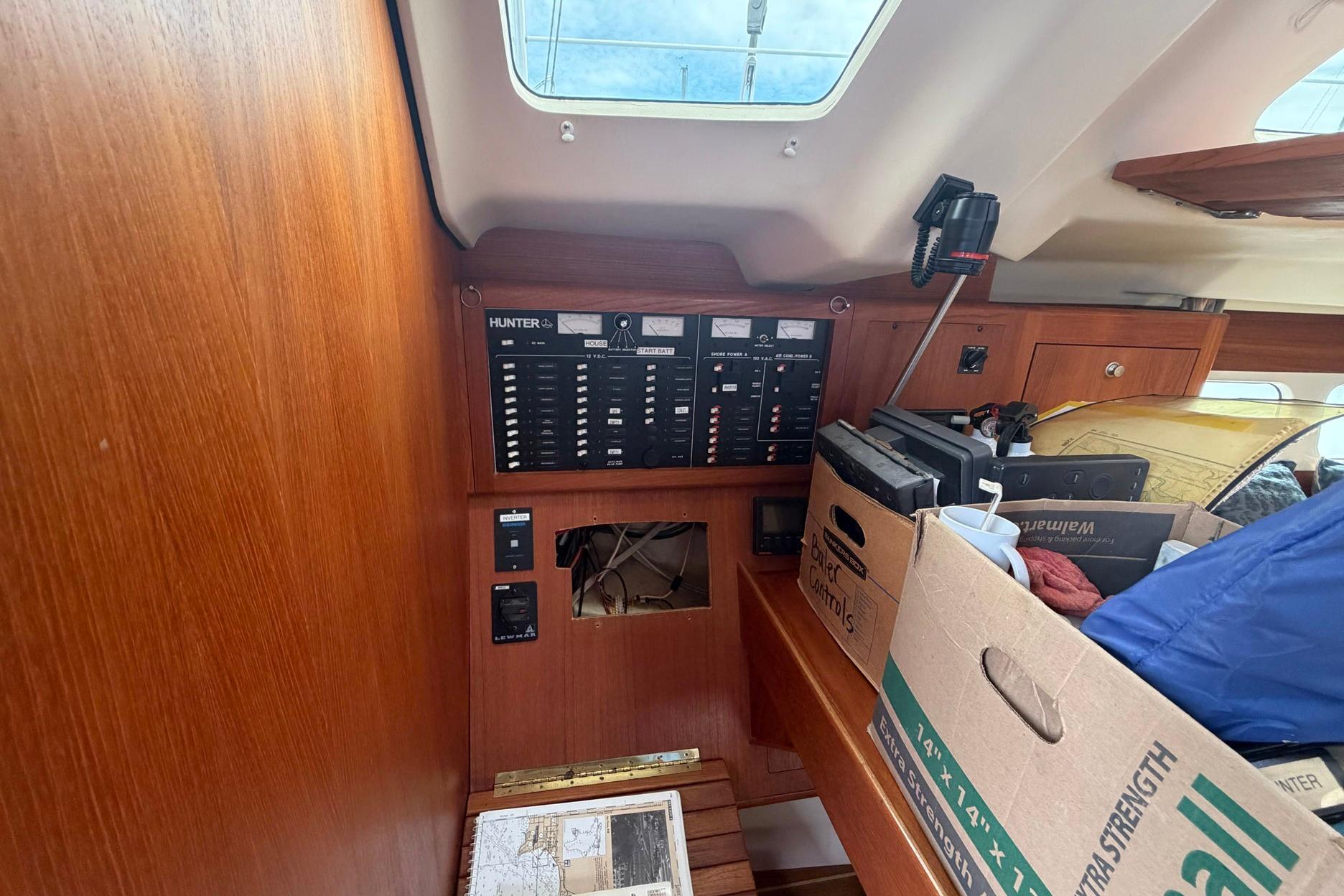 Interior of a 1998 Hunter 410 sailboat with control panel and storage boxes.