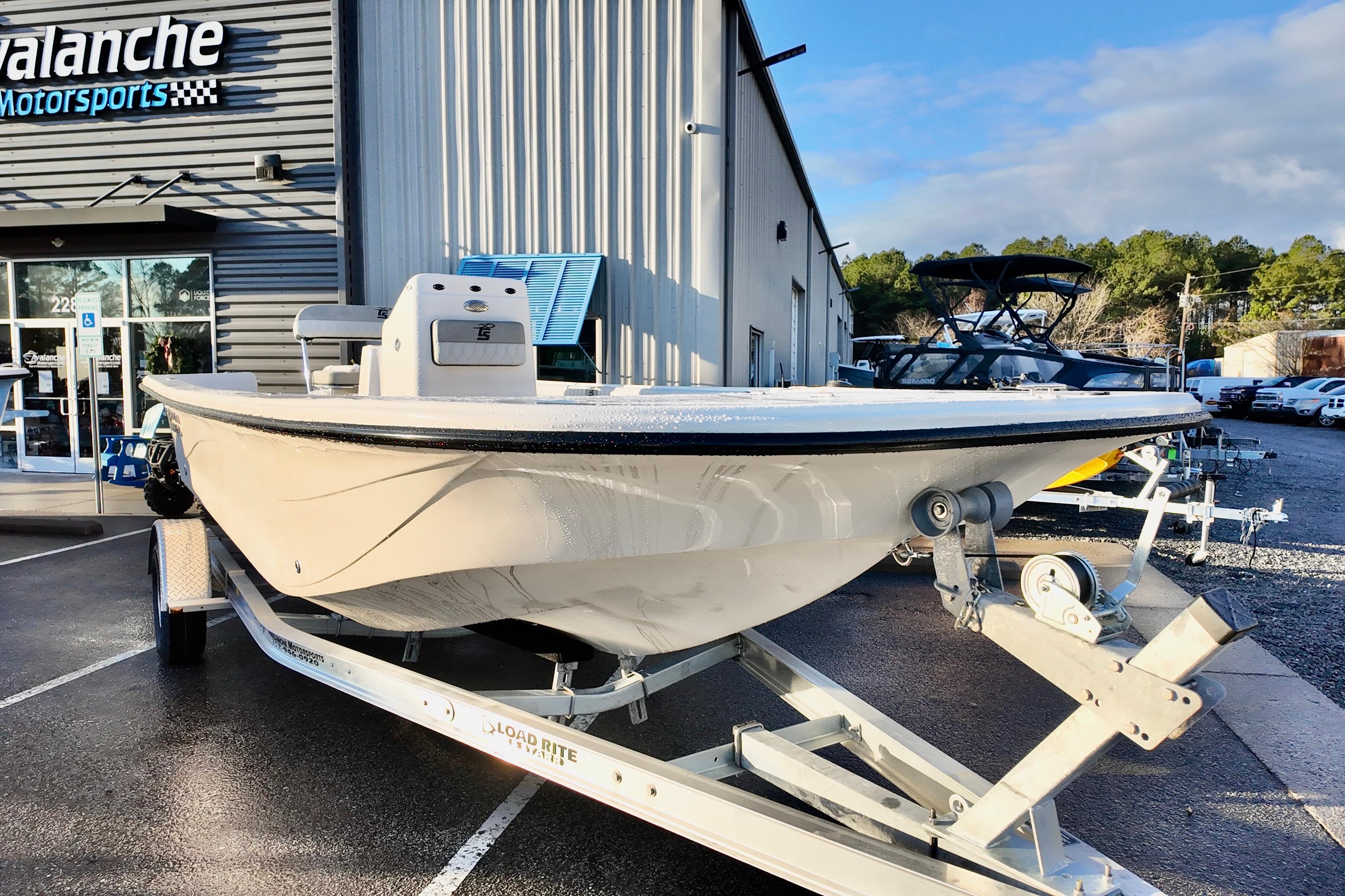 2026 Carolina Skiff 21 LS boat on trailer outside dealership, sunny day.