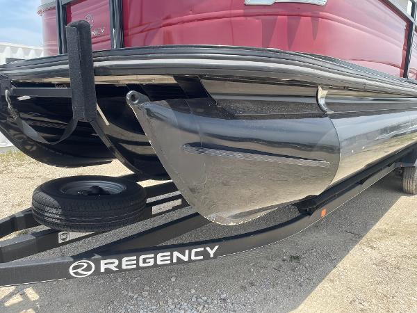 2023 Regency 250 DL3 pontoon boat on trailer, close-up view of hull and logo.